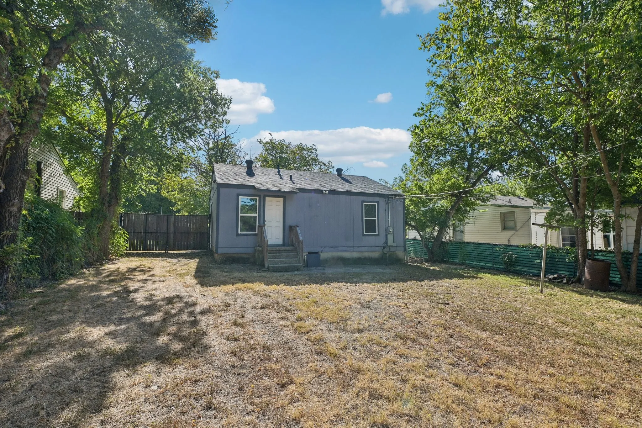 Expansive yard with mature trees and a privacy fence