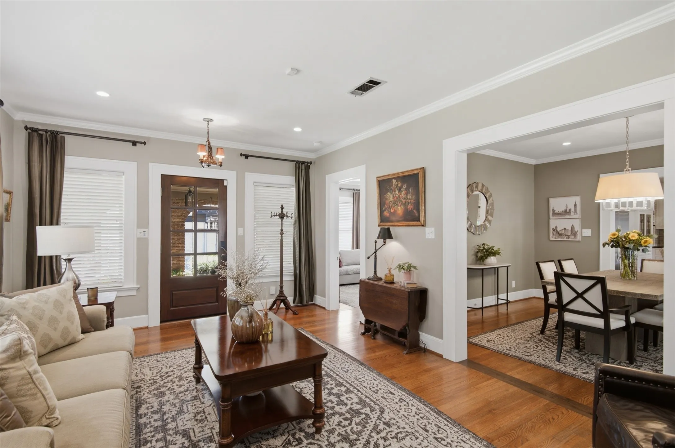 Hardwood flooring, recessed lighting, crown molding, cased openings, and a paneled entry door