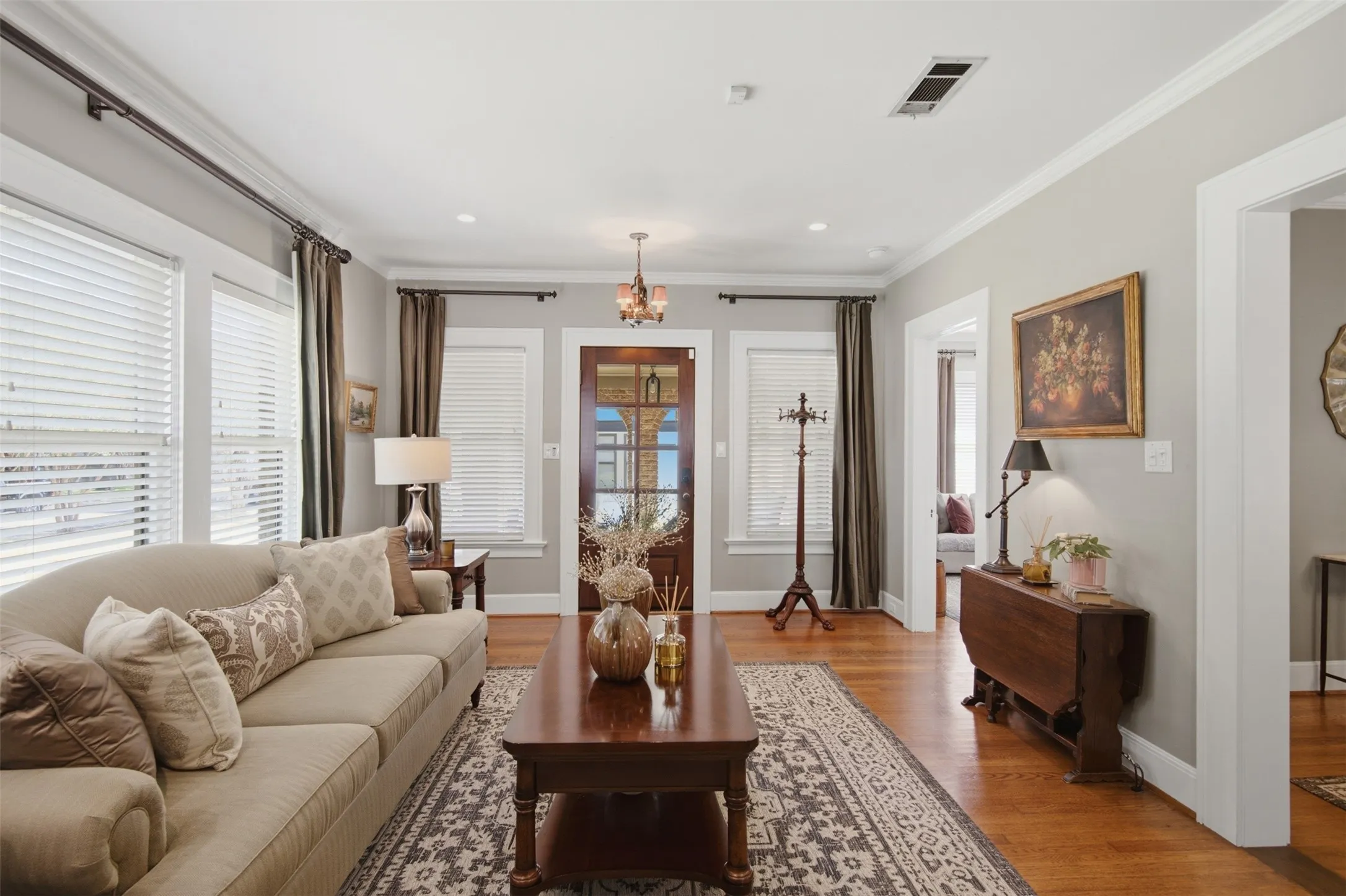 Hardwood flooring throughout, crown molding, recessed lighting, white window blinds, and a paneled entry door with glass inserts