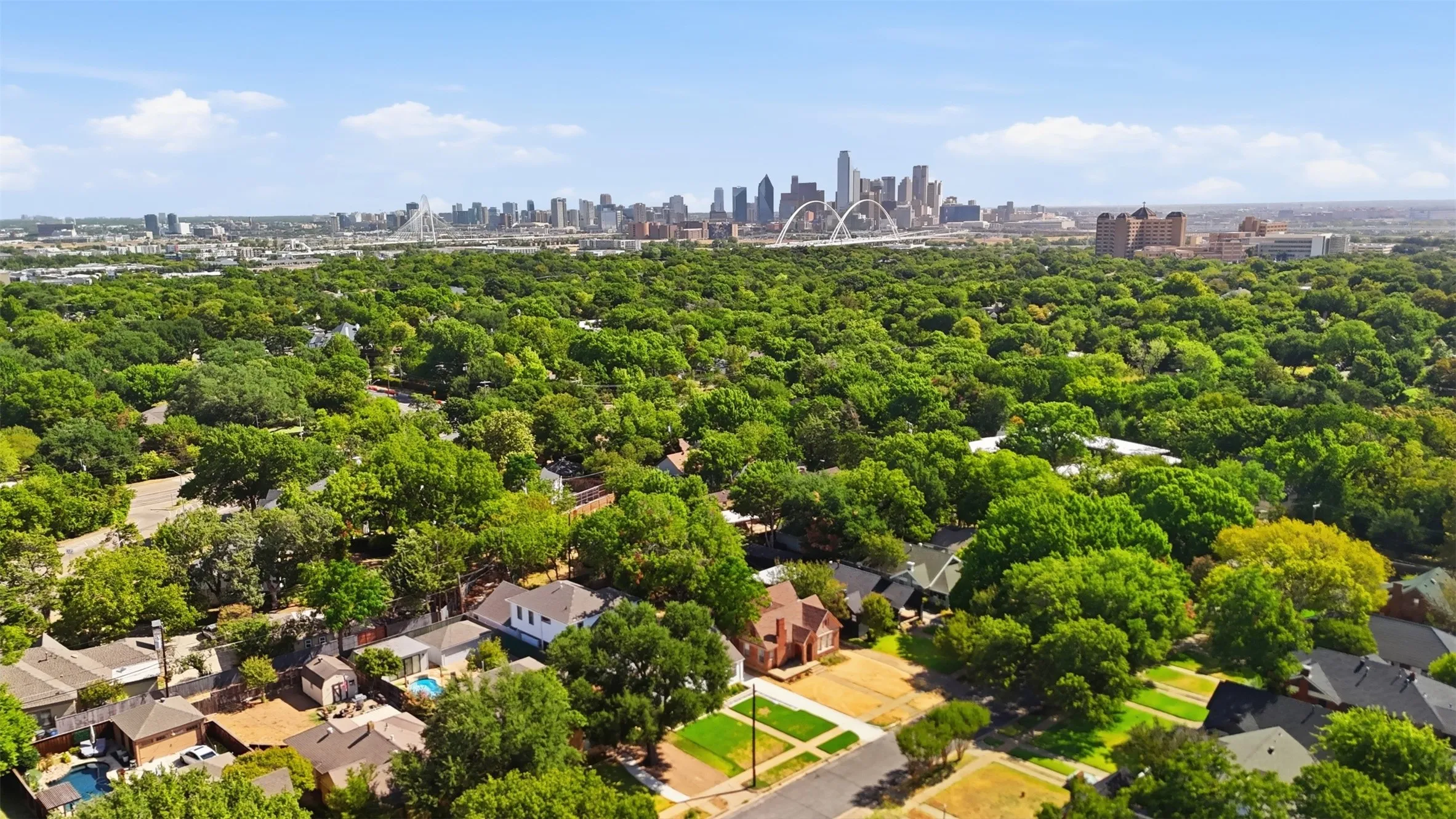 Drone photography taken from the home. Expansive green tree canopy with a distant Dallas skyline. This neighborhood is close to all of the great amenities Dallas has to offer, Downtown/Uptown, Stevens Park Golf Course, Bishop Arts, Coombs Creek Trails, two blocks from Kidd Springs Park and its fabulous Japanese Gardens and spring fed pond.