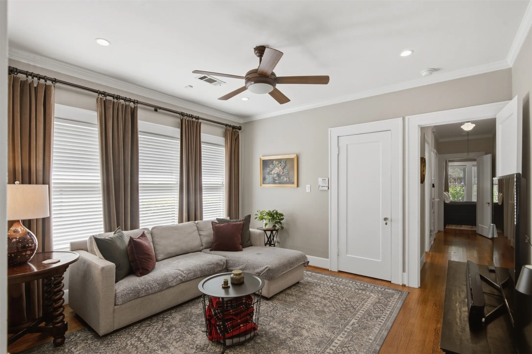 Hardwood flooring throughout, recessed lighting, crown molding, and a ceiling fan with integrated lighting. Third bedroom can function as a secondary living area.