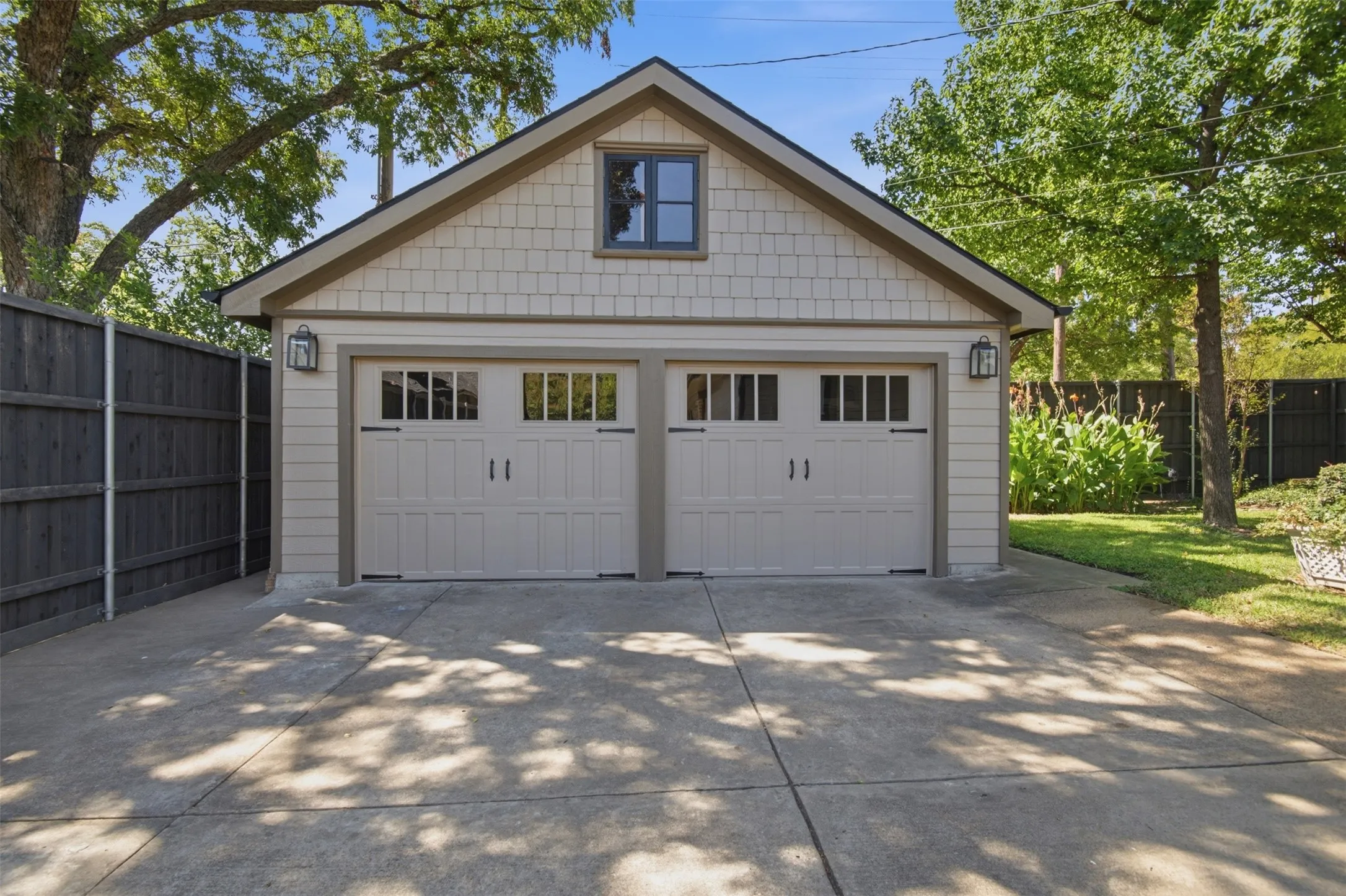 Detached newly built two-car garage with shaker siding and gable roof. Additional storage in attic.