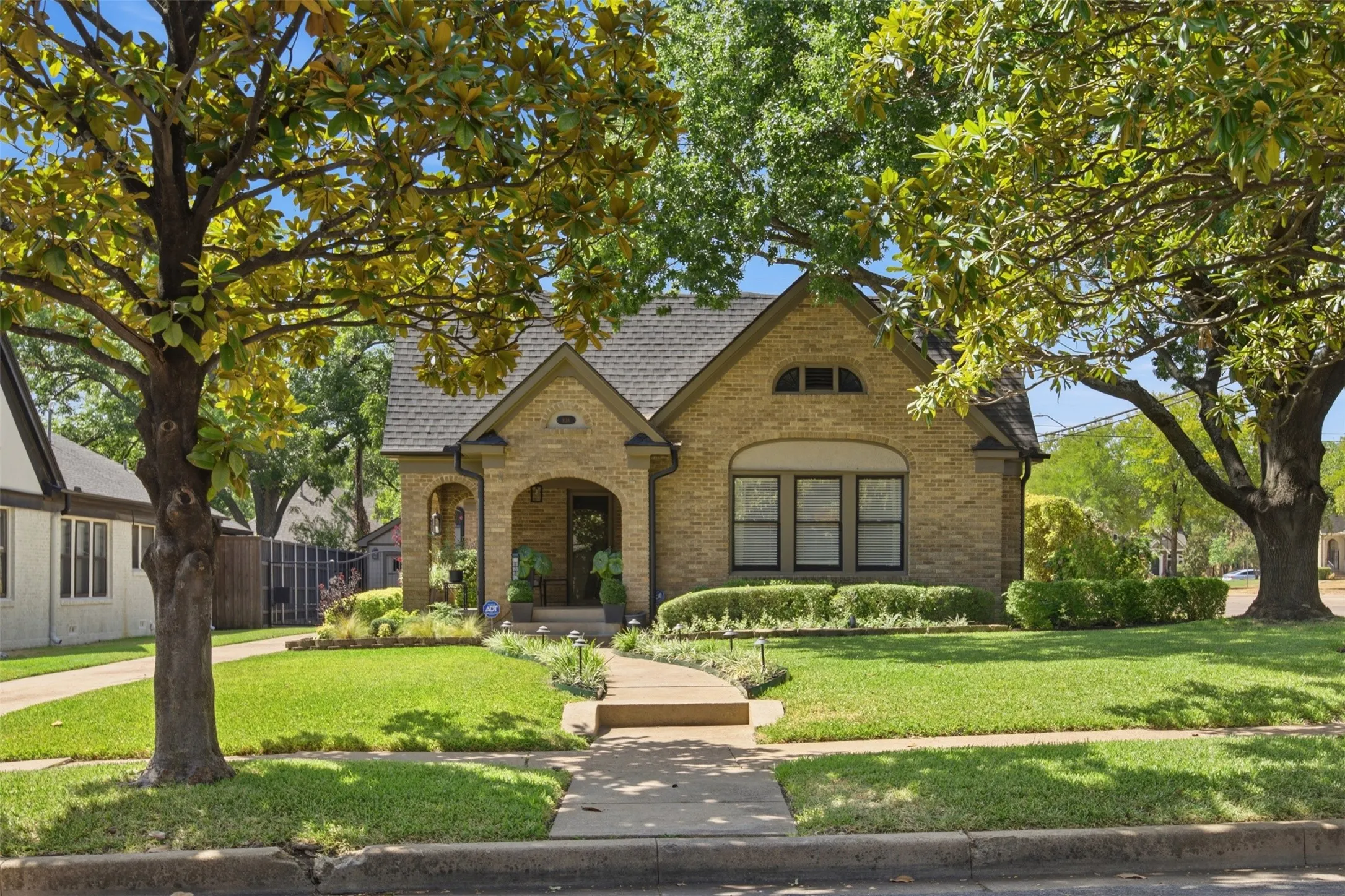Exquisite Brick Tudor exterior construction with a covered arched entry
