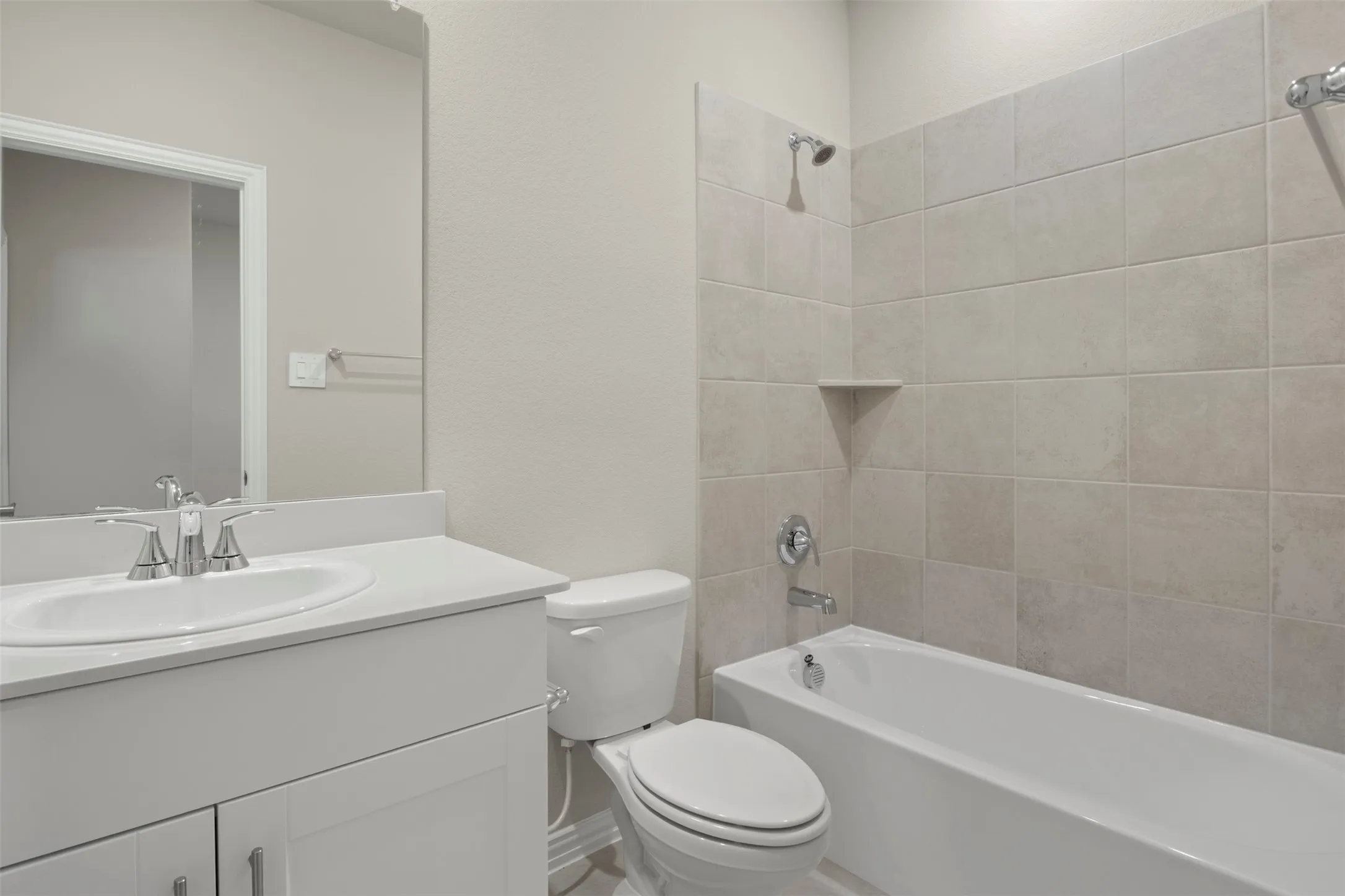 Bathroom featuring a white vanity with an integrated sink, polished chrome faucet, and a large mirror