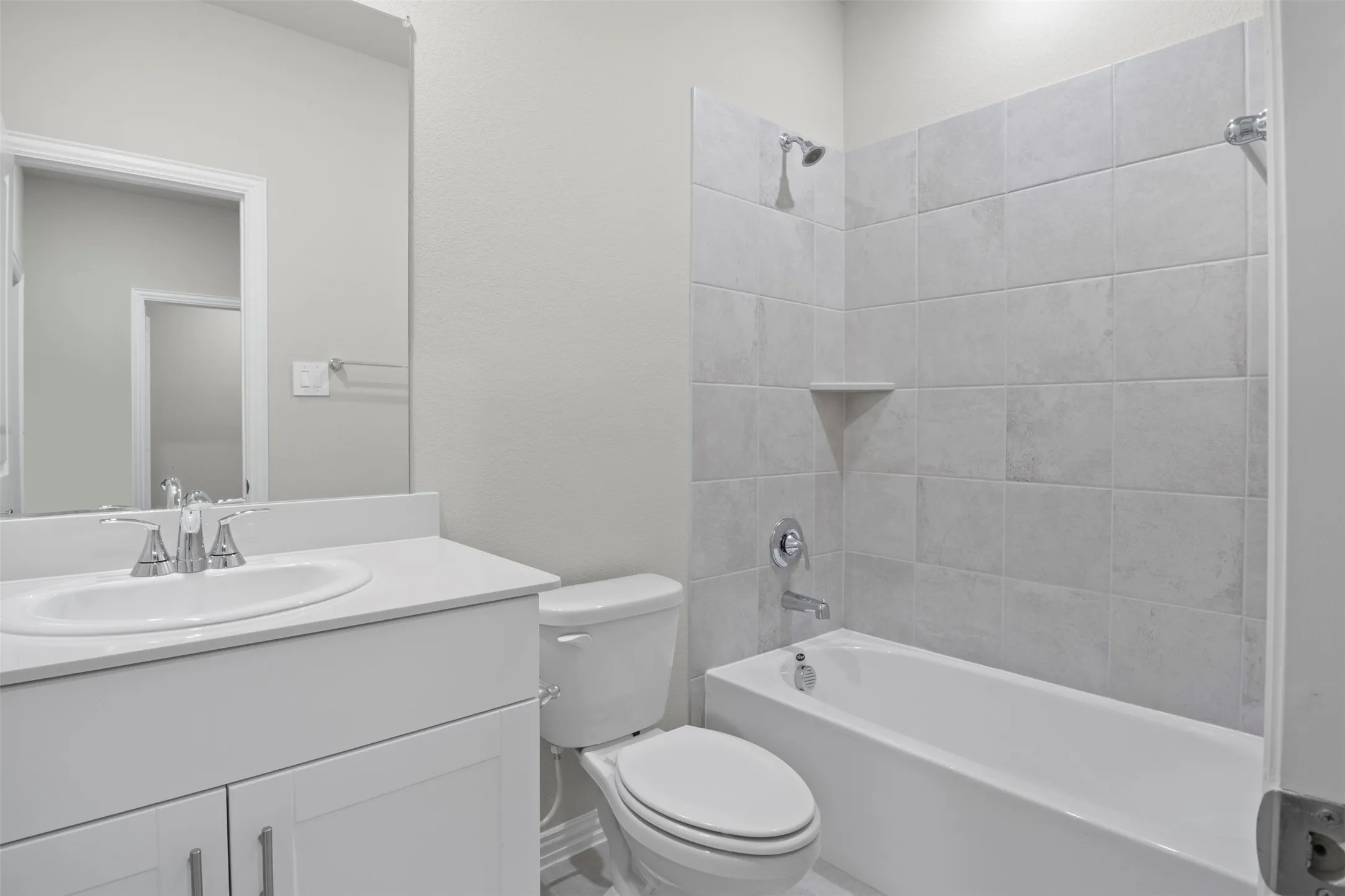 White vanity with integrated sink, chrome faucet, and rectangular mirror