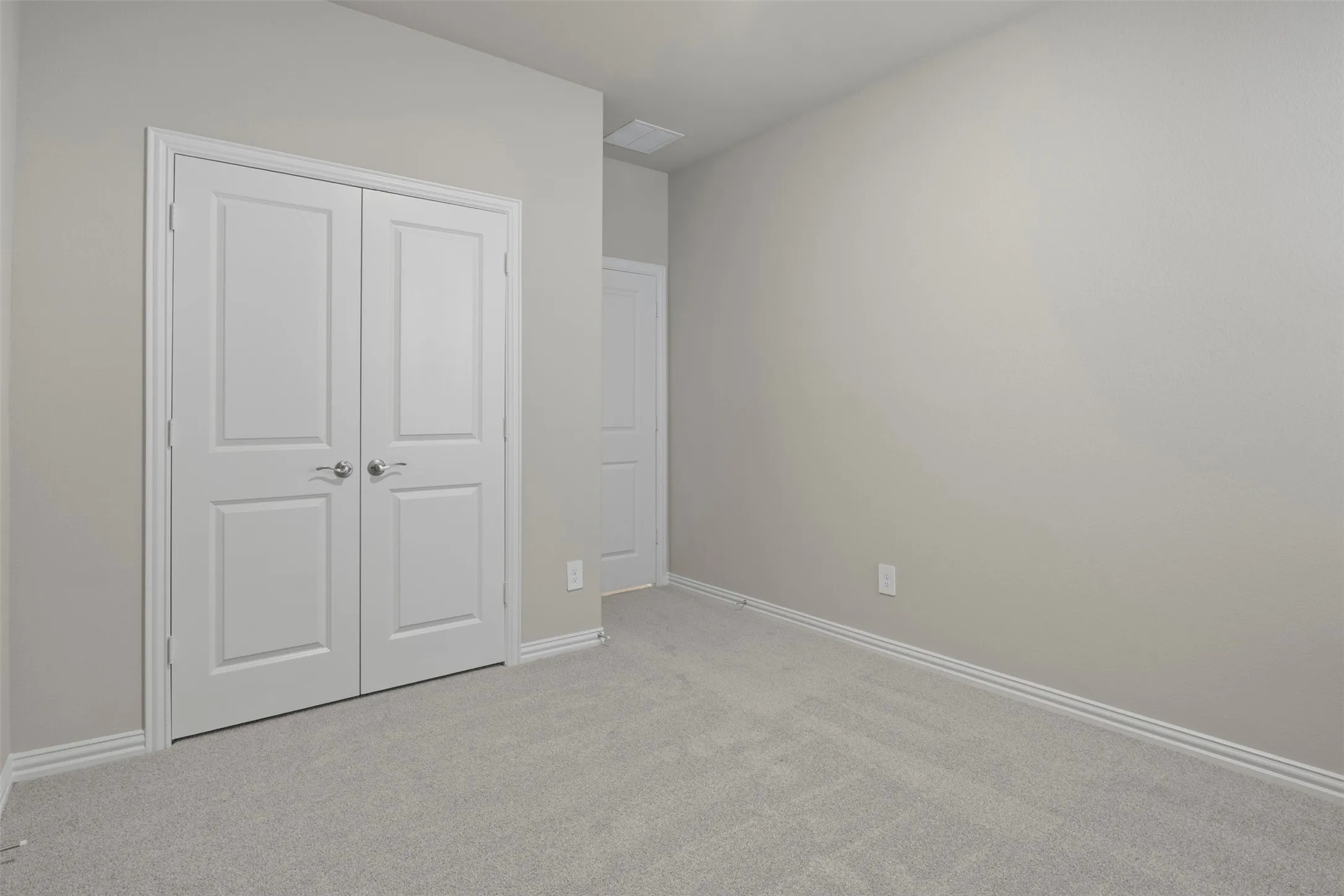 Soft gray carpet flooring complemented by light gray walls, white trim, and white paneled doors