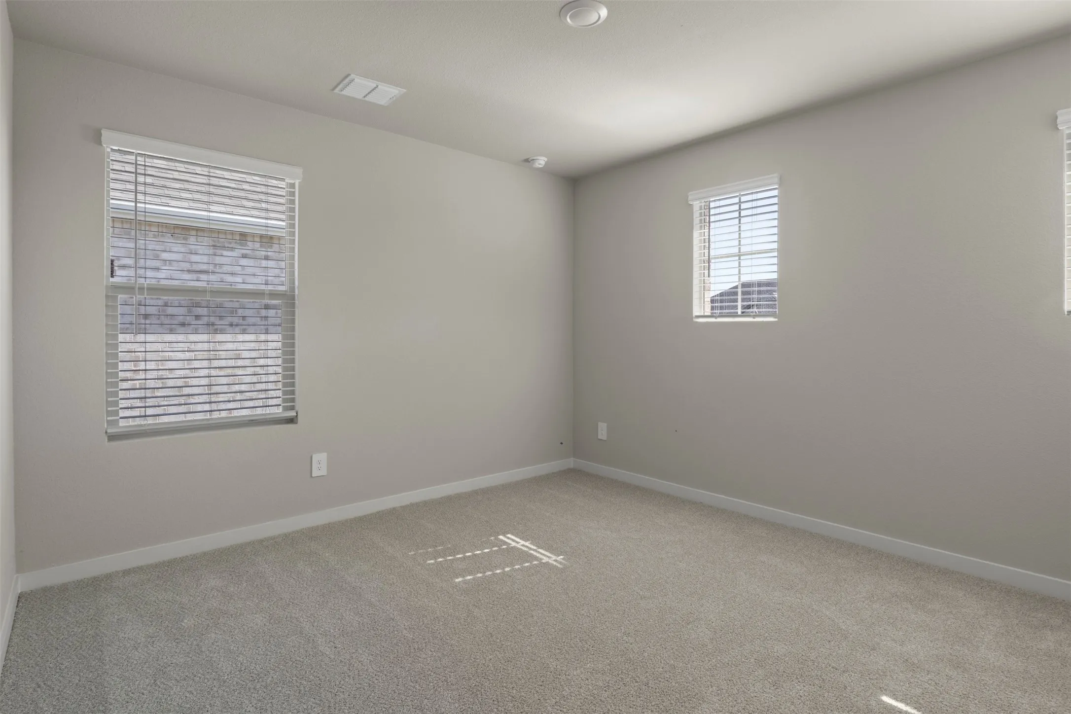 Recessed ceiling lighting, light-toned walls, and neutral carpeting