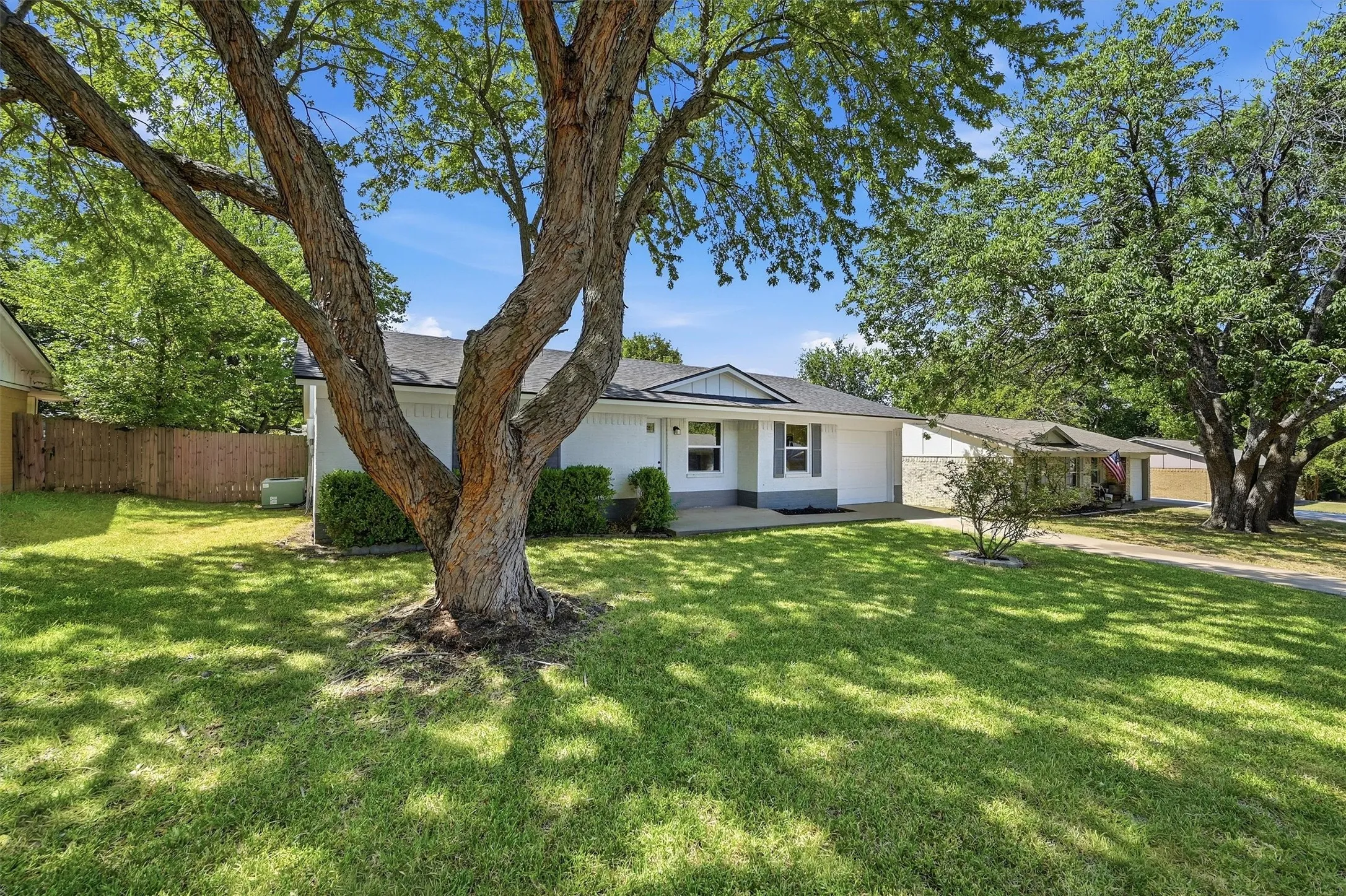 White exterior with dark gray shutters, front porch entry, and a well-maintained lawn