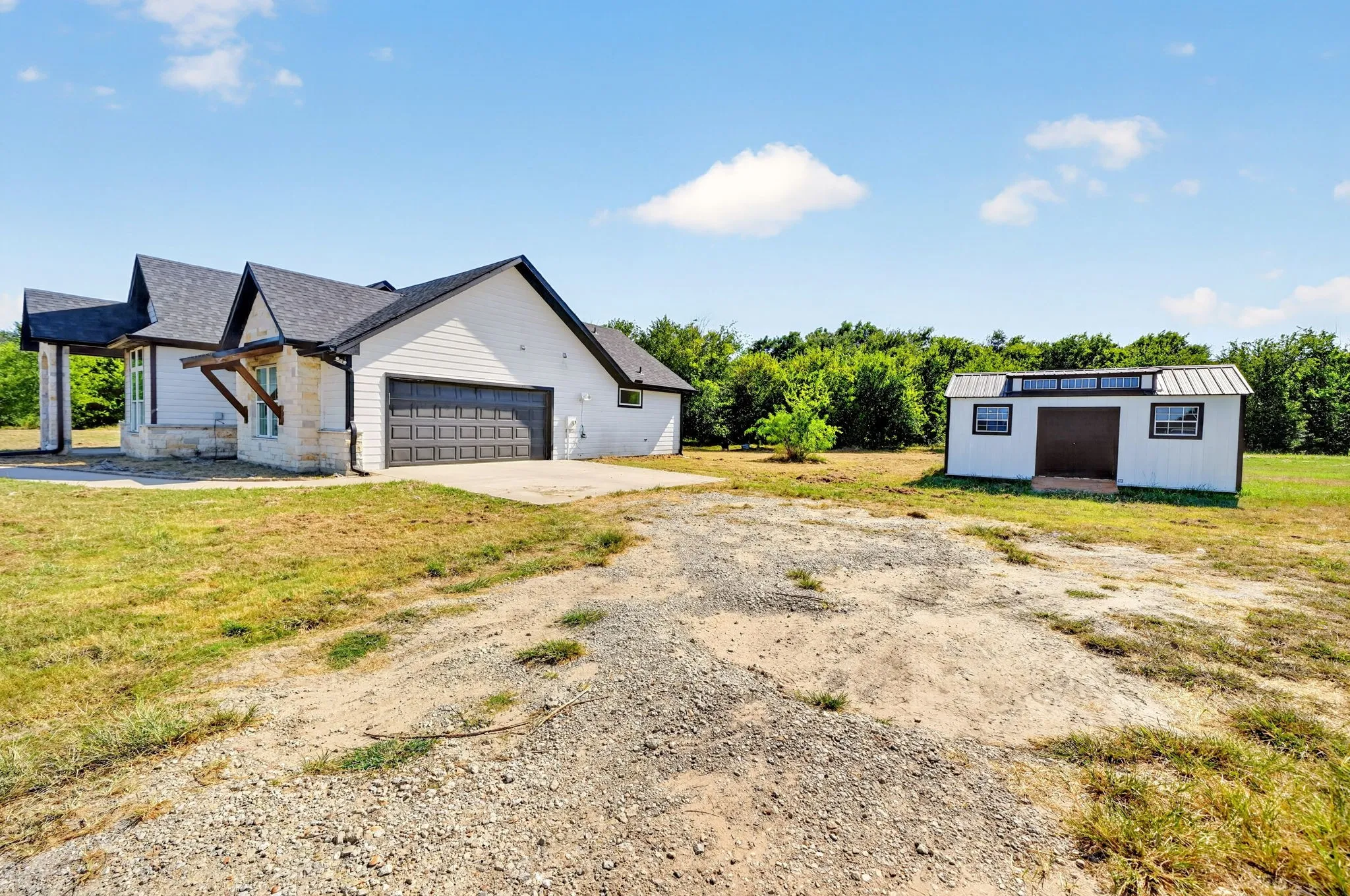 Modern farmhouse exterior with white siding and stone accents
