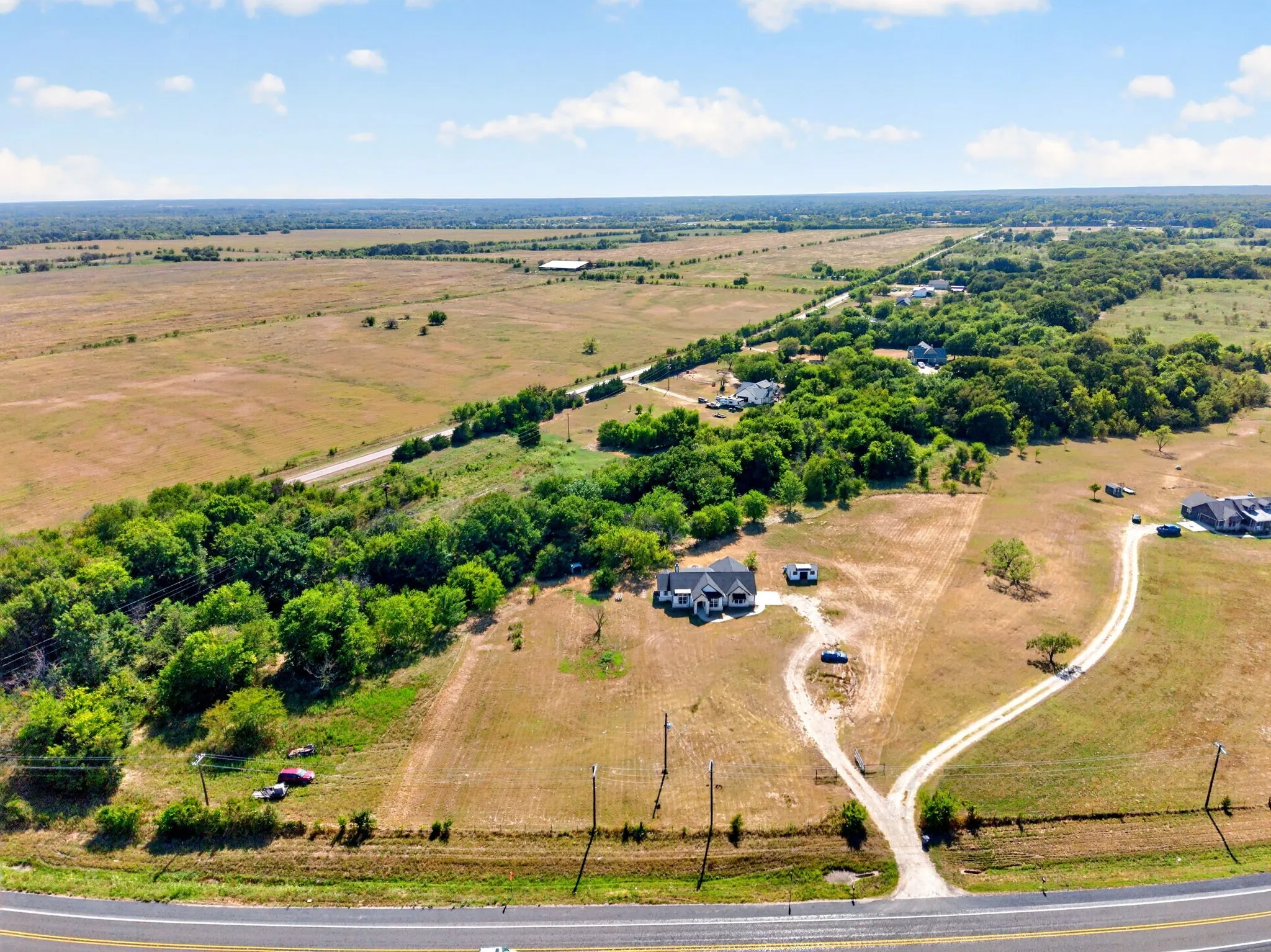 Expansive property featuring a single-story home, extensive green space, and mature trees