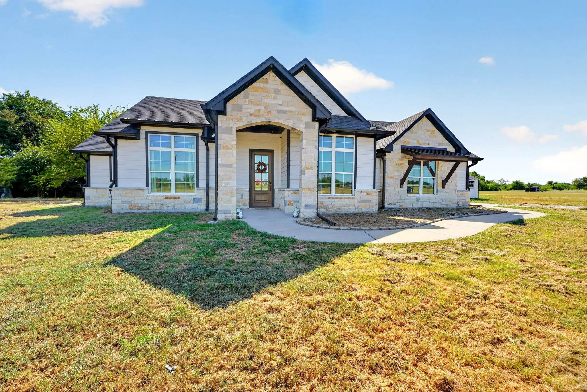 Stone and siding exterior with dark trim accents