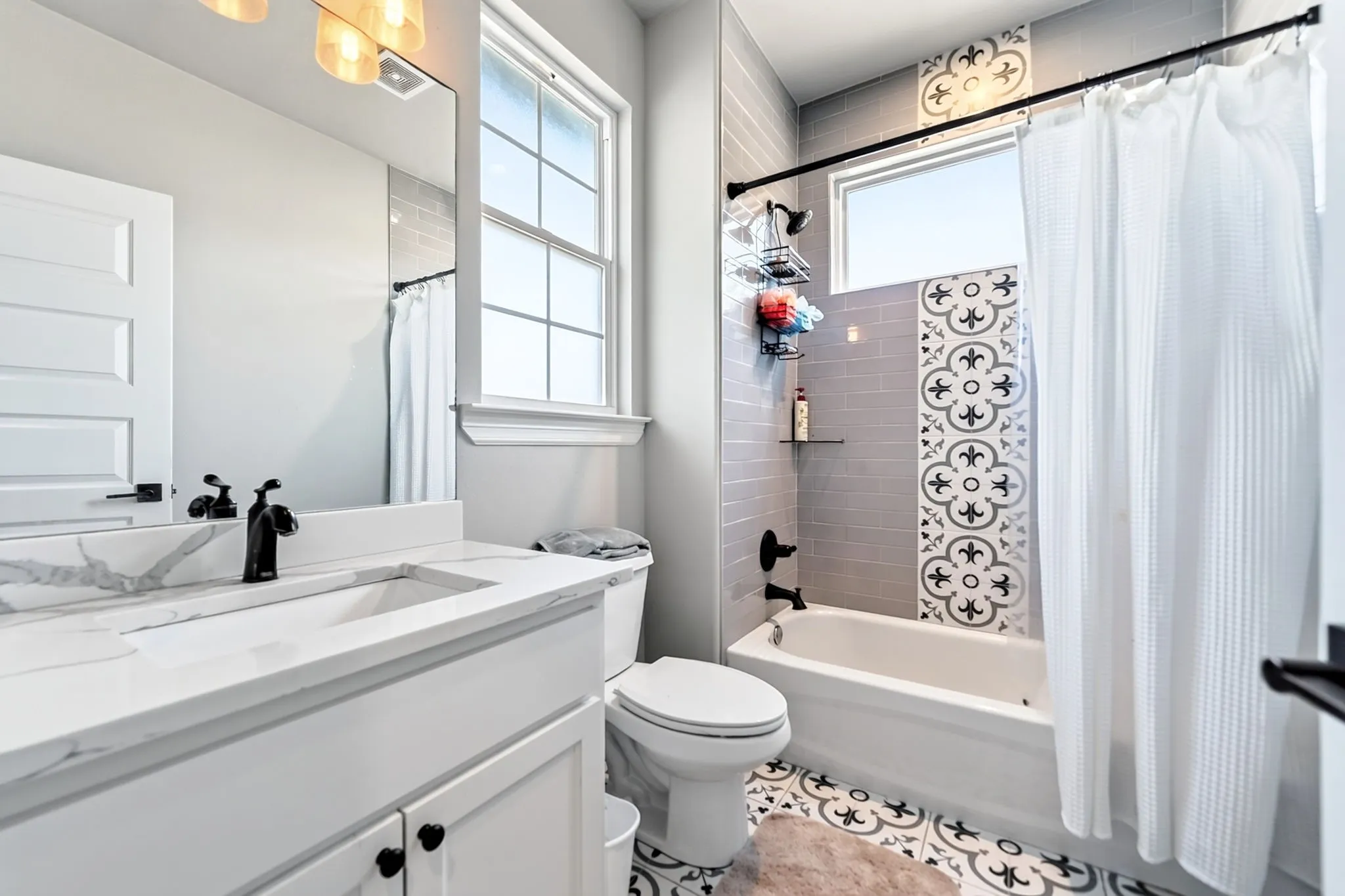White vanity with a rectangular sink and black faucet, framed mirror, and built-in lighting