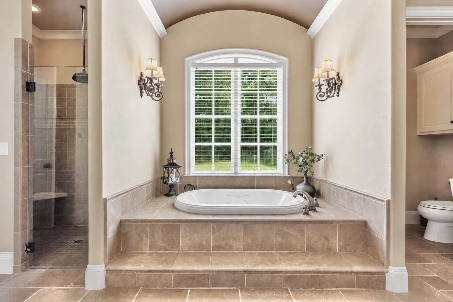 Private Primary Suite Retreat featuring a jetted tub, large walk-in tiled shower, dual vanities, spacious walk-in closet with built-ins, abundant storage, custom cabinetry, and a stunning circular domed ceiling accent.
