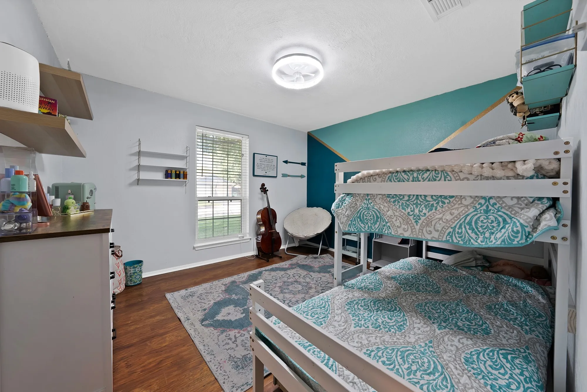 Wood-finish flooring, a ceiling-mounted light fixture, and a window with blinds