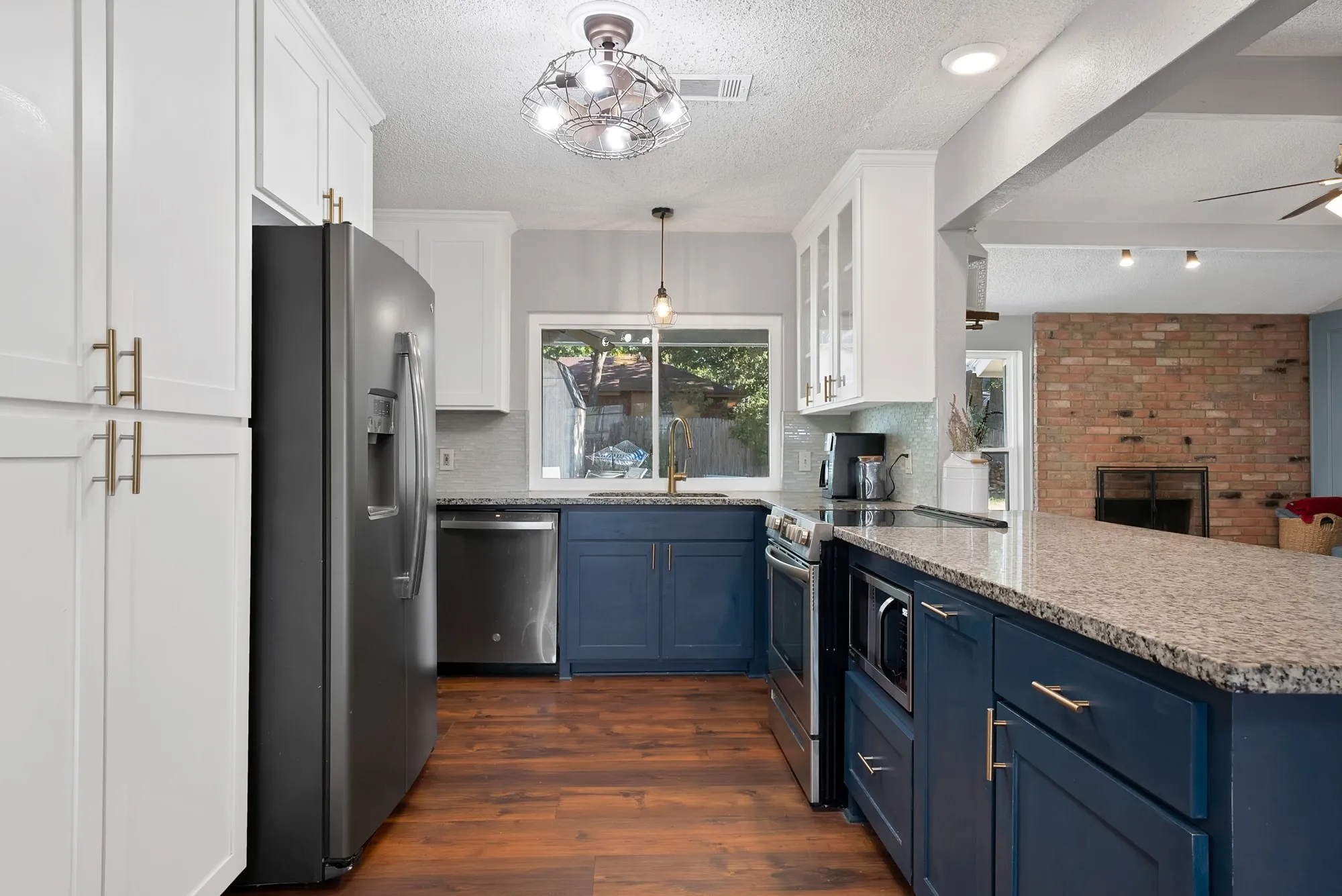 Updated kitchen featuring white upper cabinetry, blue lower cabinetry, and wood-finish flooring