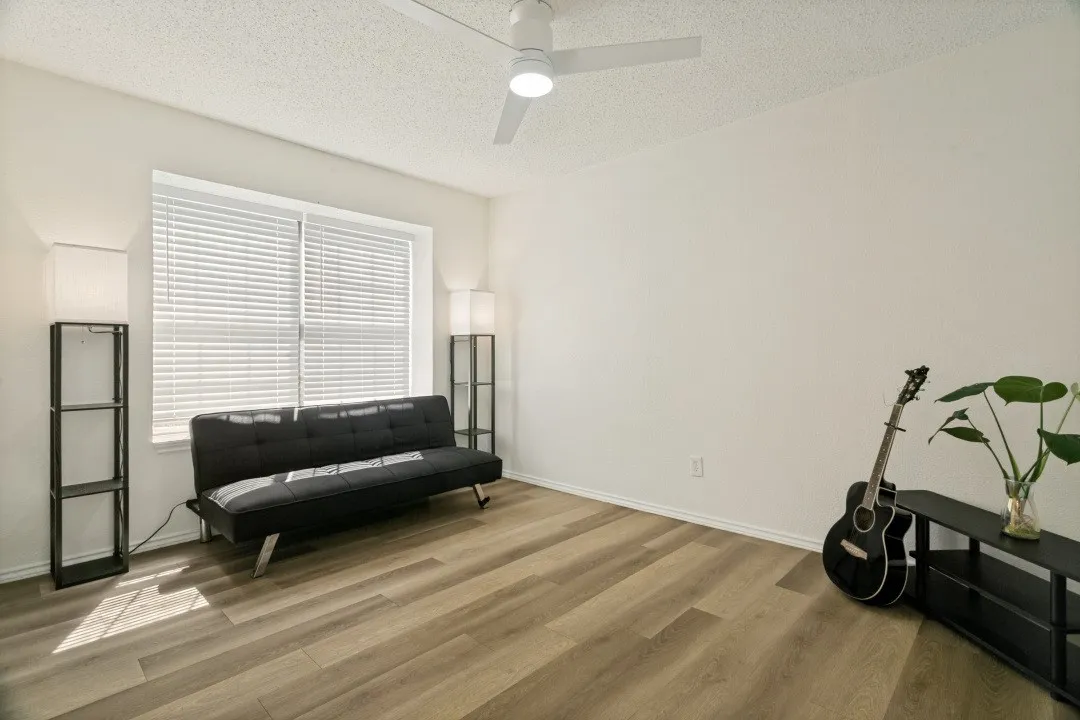 Spare room with a textured ceiling, ceiling fan, and hardwood / wood-style flooring