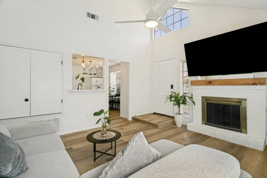 Living room with ceiling fan with notable chandelier, dark hardwood / wood-style floors, and a wealth of natural light
