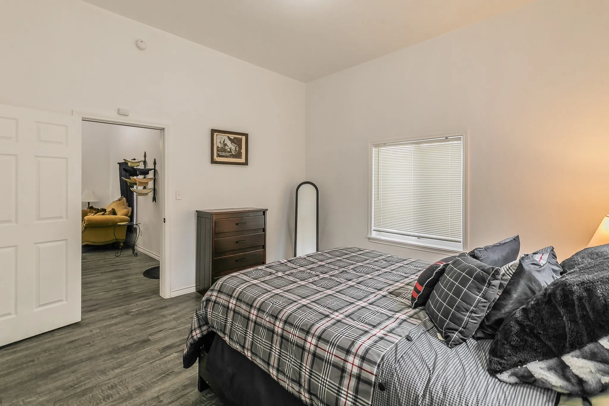 White walls, wood-finish flooring, and a window with blinds