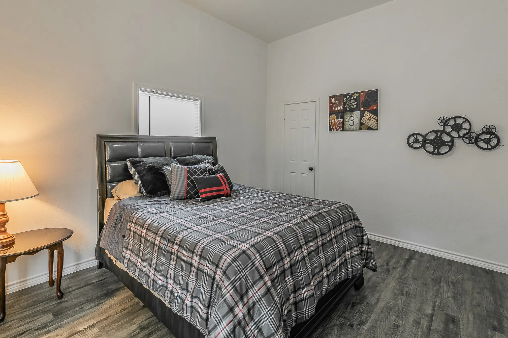 Wood-finish flooring, white walls, and a white interior door