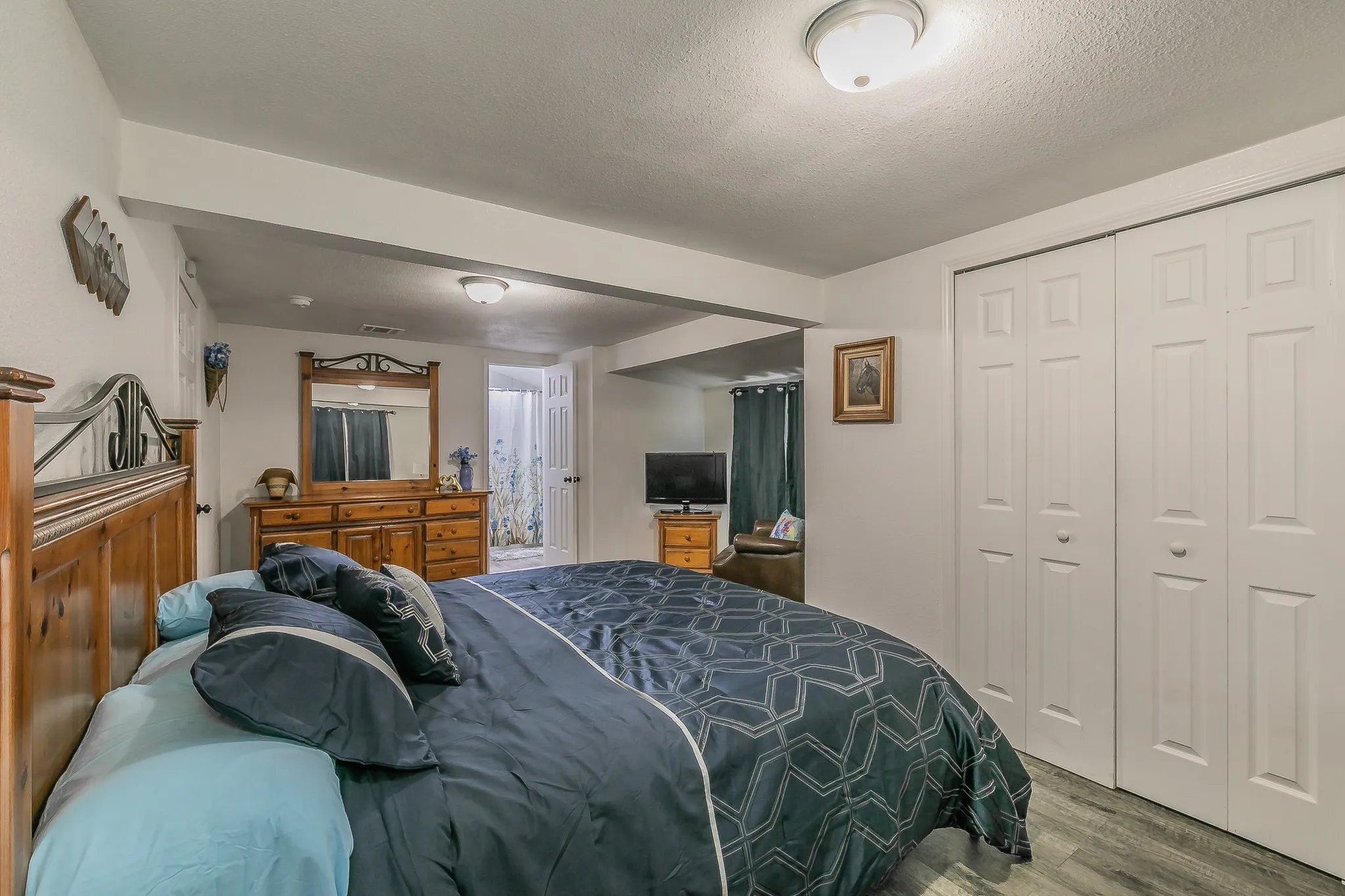 Wood-finish flooring, recessed lighting, and a bi-fold closet with panel doors