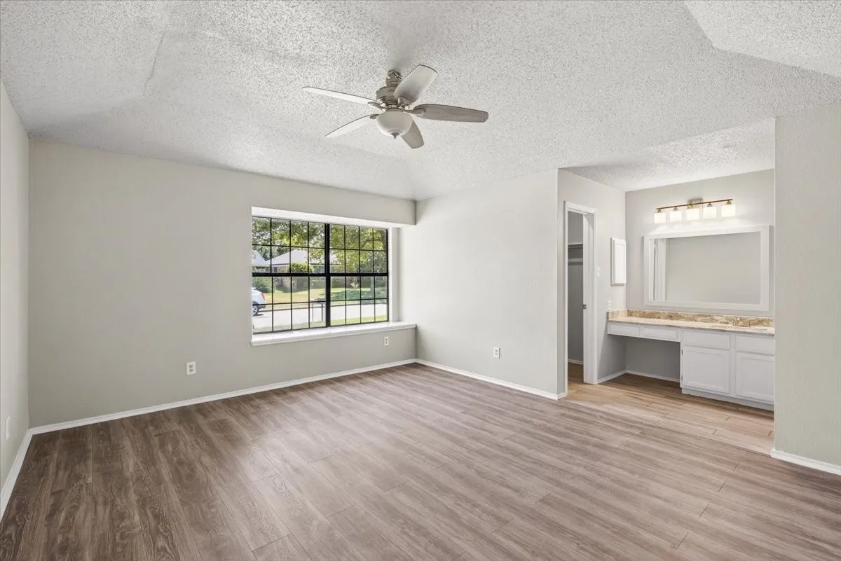 Split primary bedroom showing views of the closet and vanity area