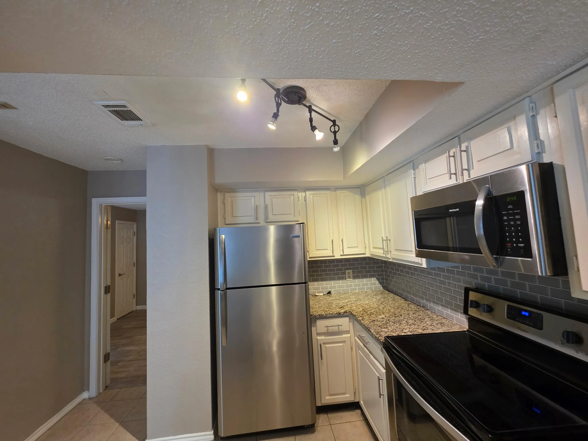 Kitchen with refridgerater , microwave, oven and stove combo, granite counter tops
