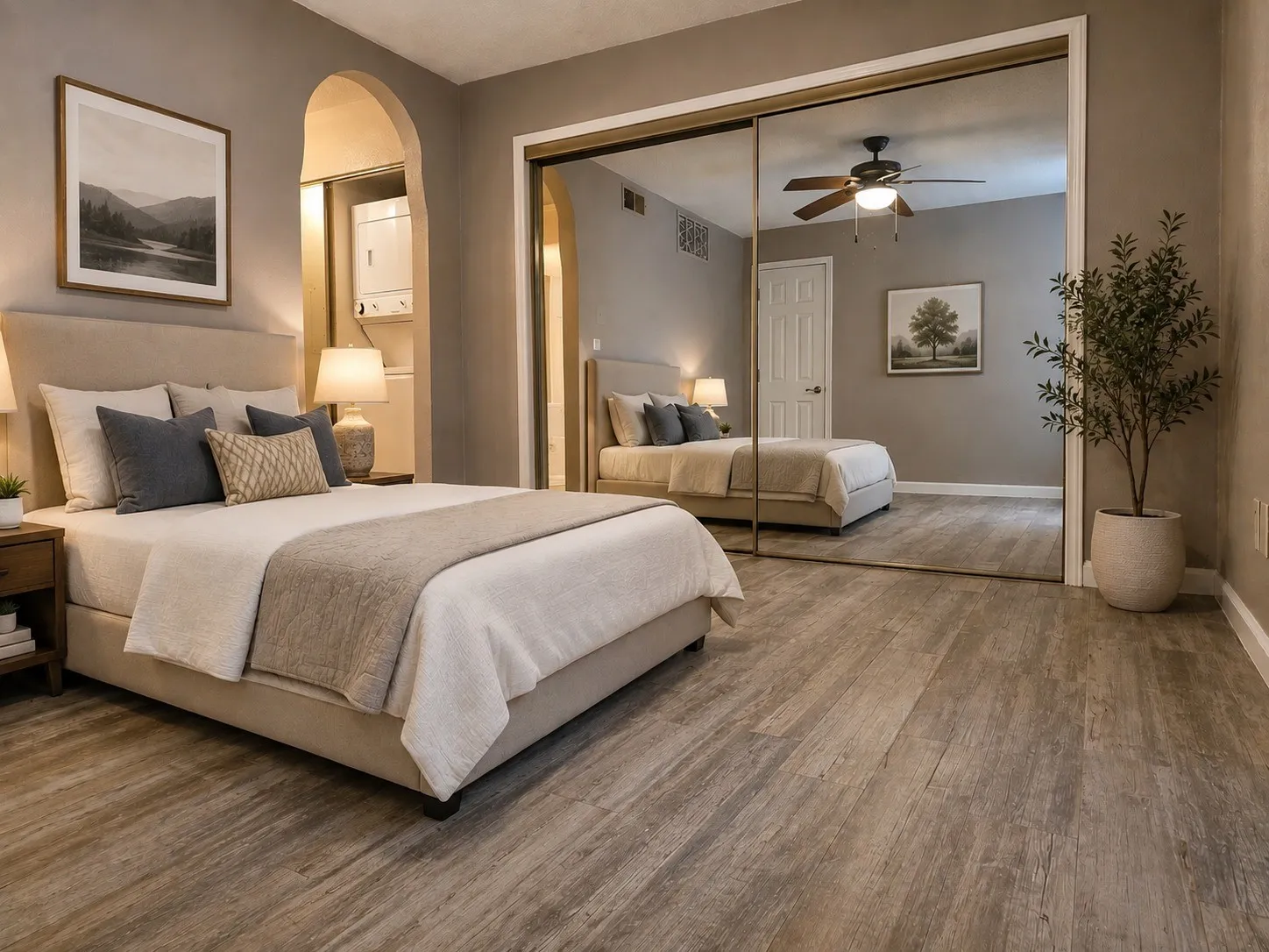 Wood-finish flooring, mirrored closet doors, arched doorway, and a ceiling fan with integrated lighting virtually staged