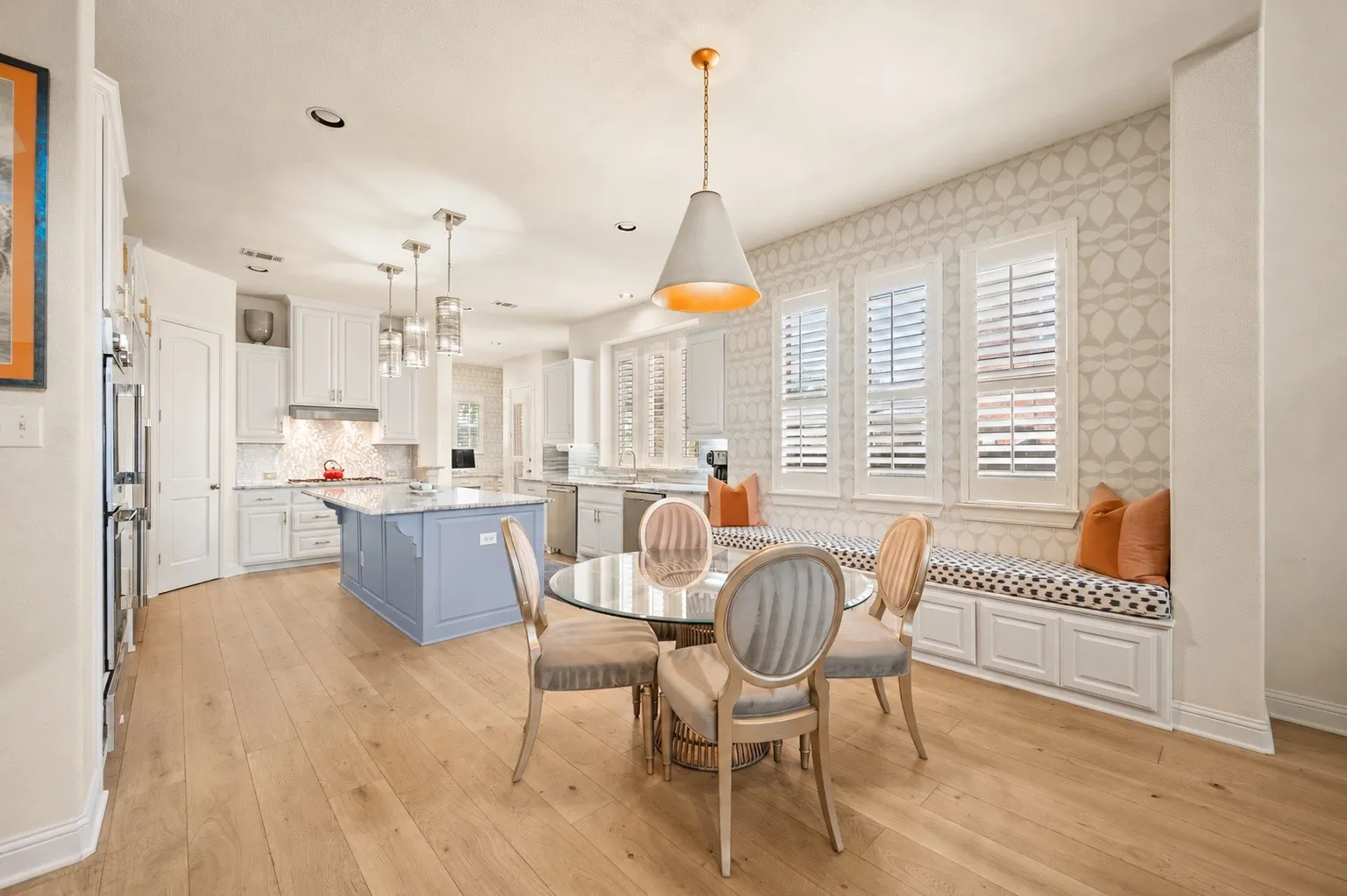 Gourmet kitchen with double wall ovens, a central island, and wood-finish flooring