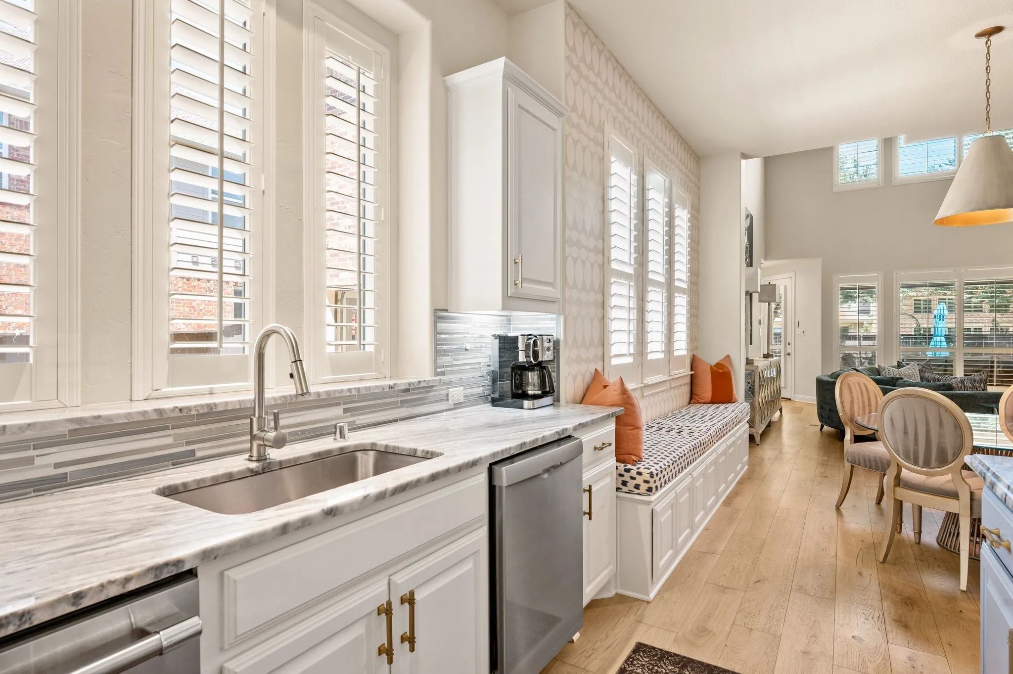 Kitchen featuring a stainless steel sink, pull-down faucet, light-toned countertop,glass tile backsplash, Bosch Dishwashers