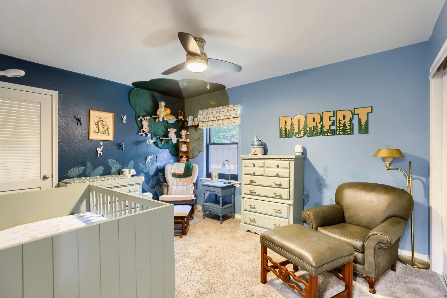 Bright, dual-toned nursery featuring soft blue walls, neutral carpet flooring, and ample natural light from ceiling fixture