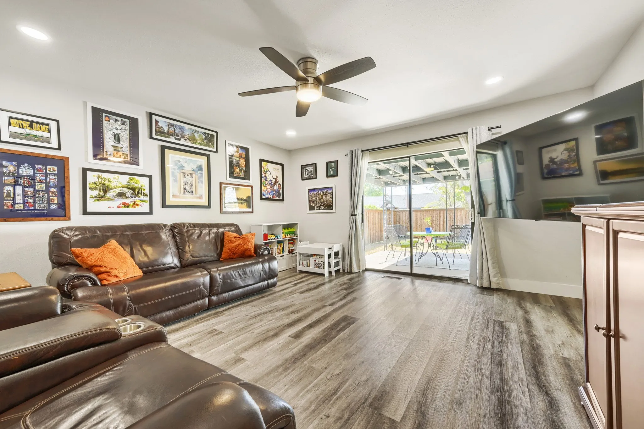 Wood-finish flooring, recessed lighting, ceiling fan, and sliding glass door