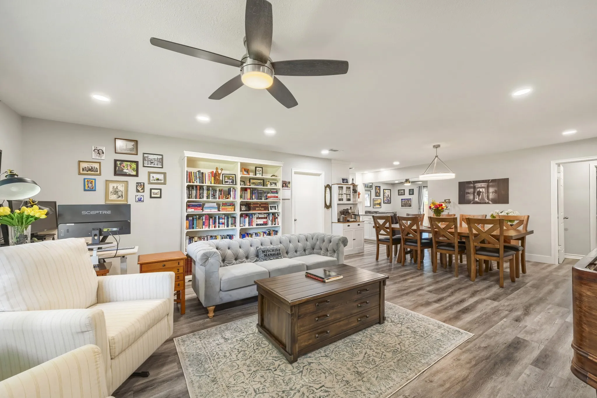Built-in shelving, recessed lighting, ceiling fan, and wood-finish flooring