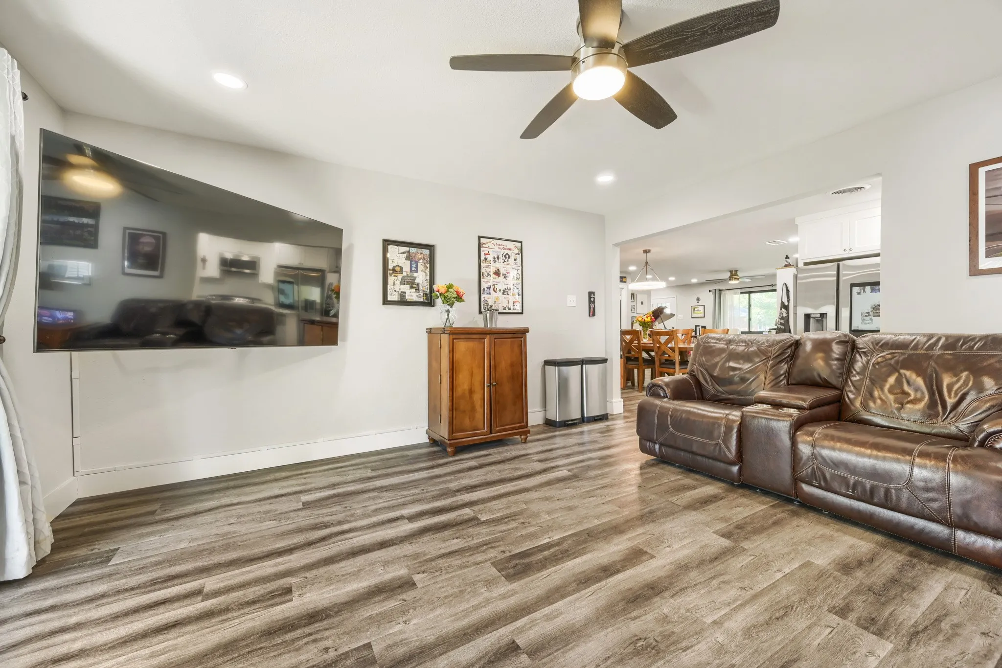 Wood-finish flooring, recessed lighting, and a ceiling fan with integrated lighting