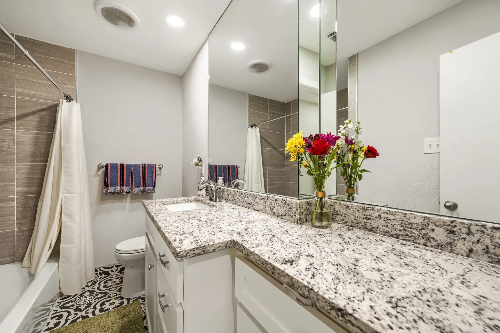 Vanity with a light-toned countertop, a rectangular sink, and chrome fixtures