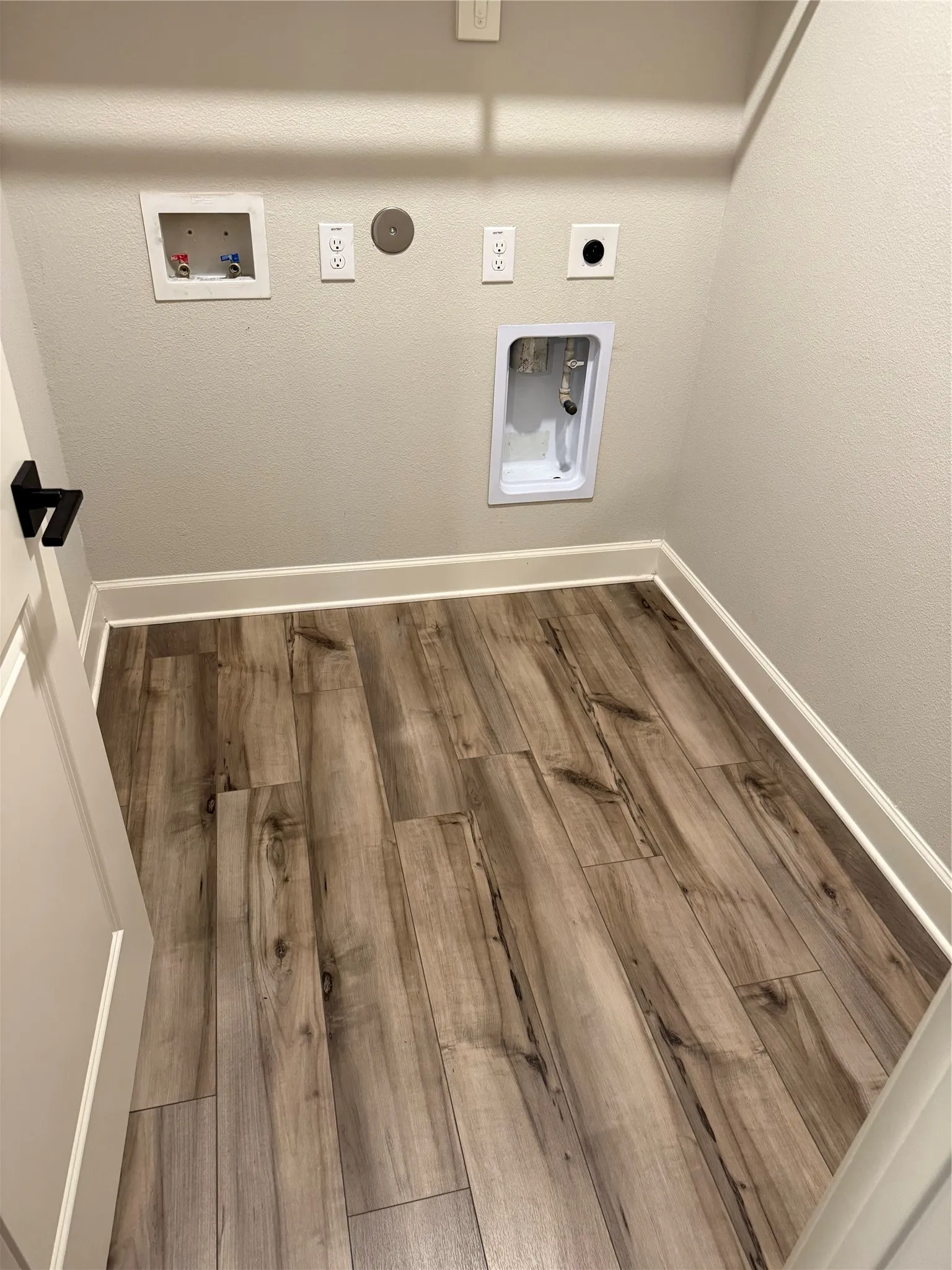 Wood-finish plank flooring with white baseboards