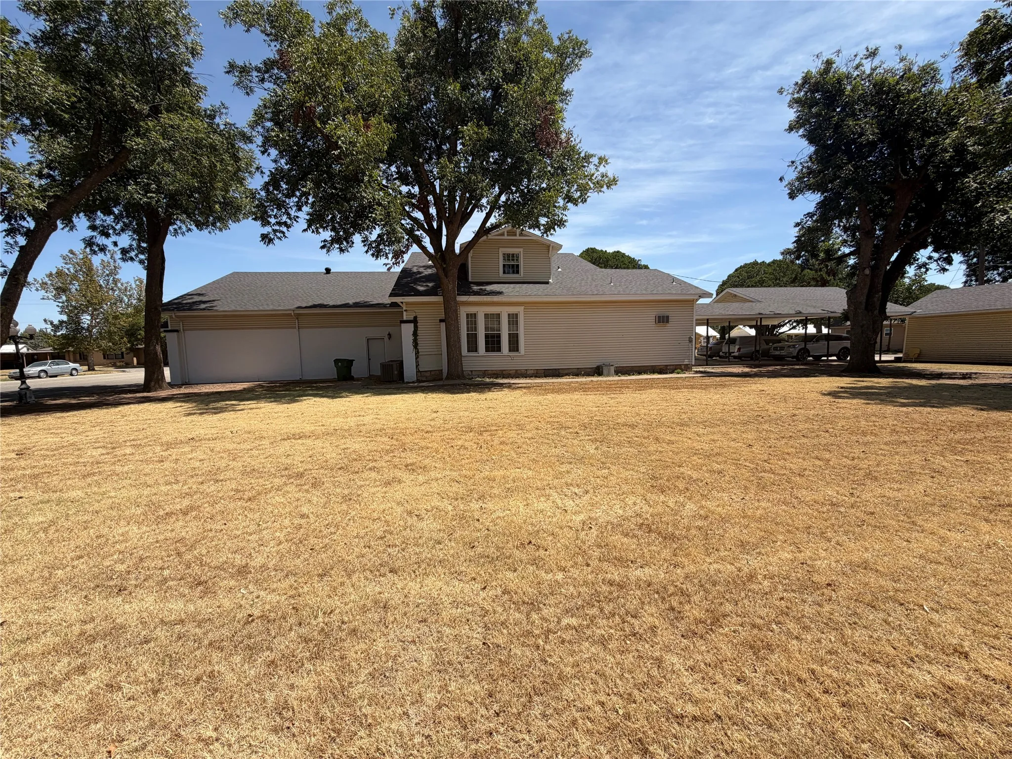 Expansive yard space with mature trees providing shade