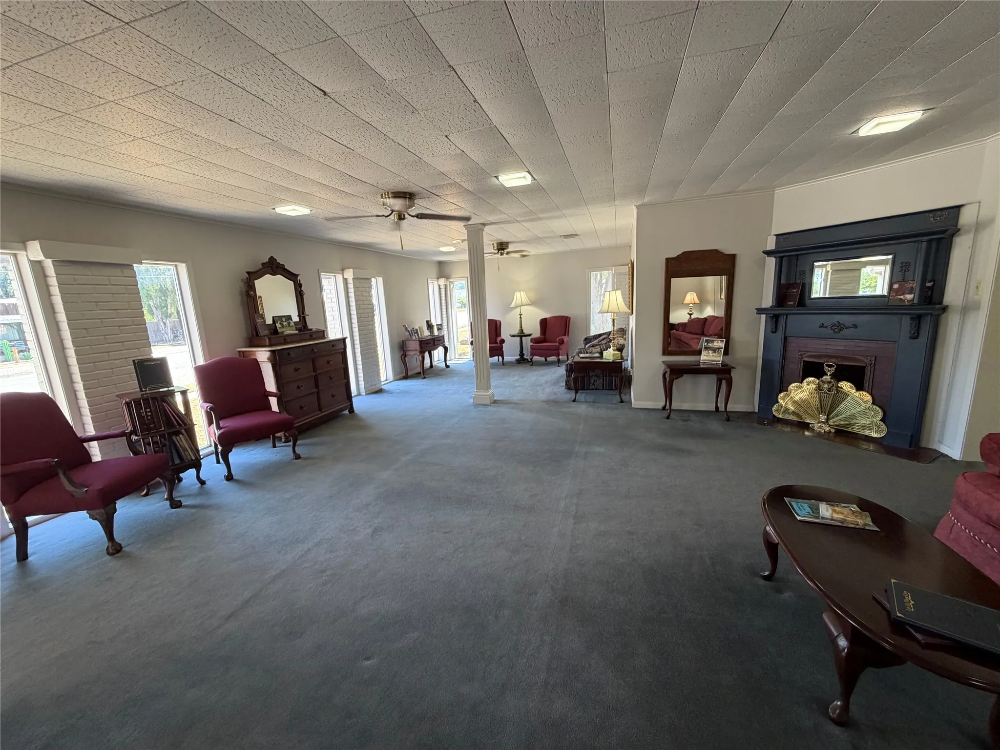Spacious interior with carpeted flooring, multiple windows, a decorative fireplace, and recessed lighting