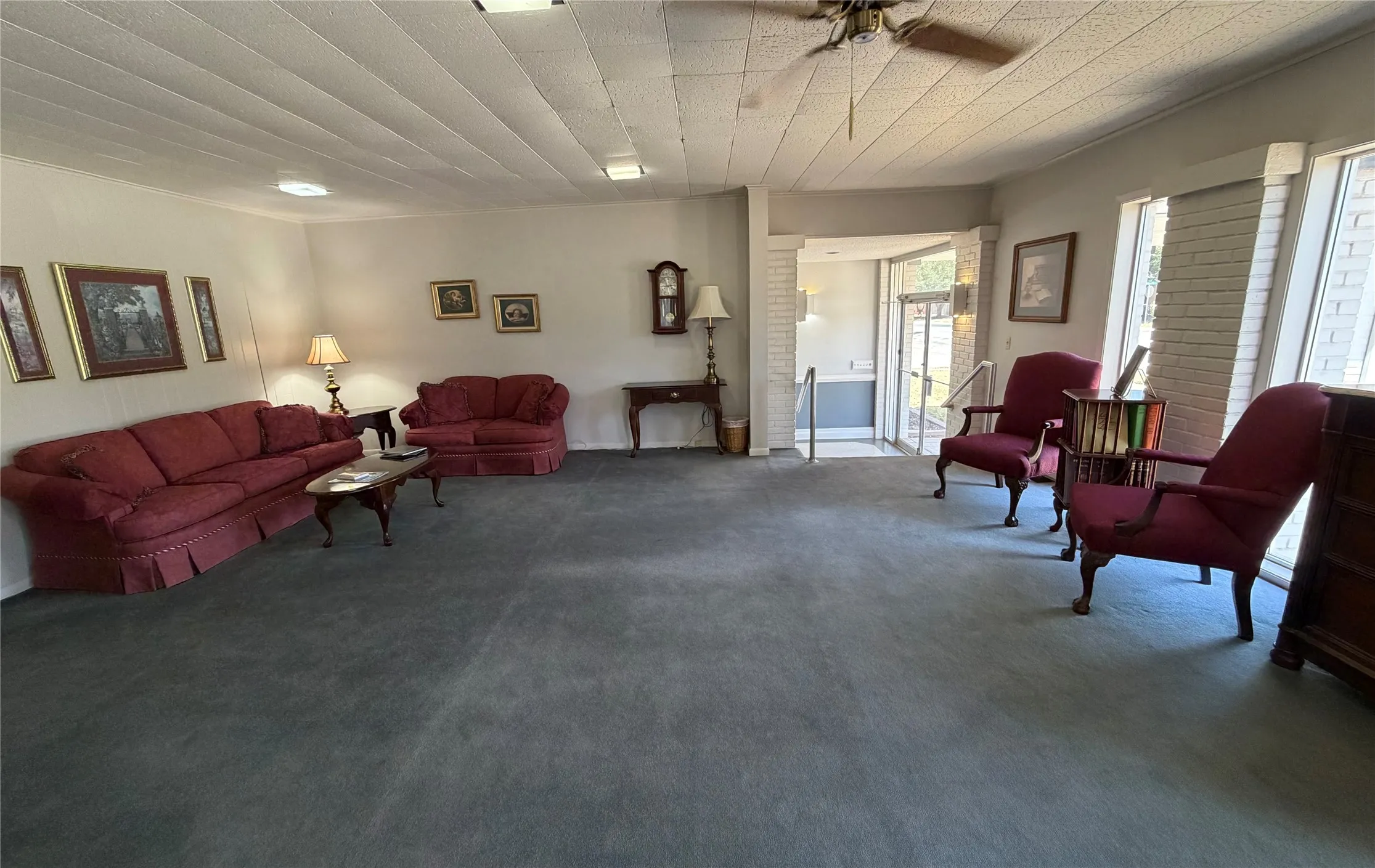 Expansive room with neutral wall tones and dark carpeting