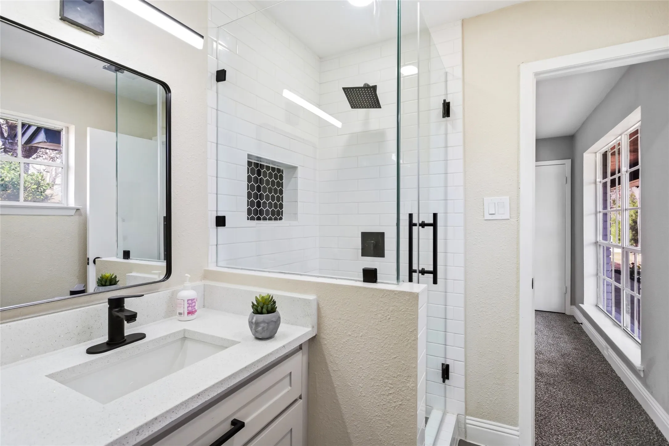 Frameless glass shower enclosure with subway tile surround and a recessed tiled niche