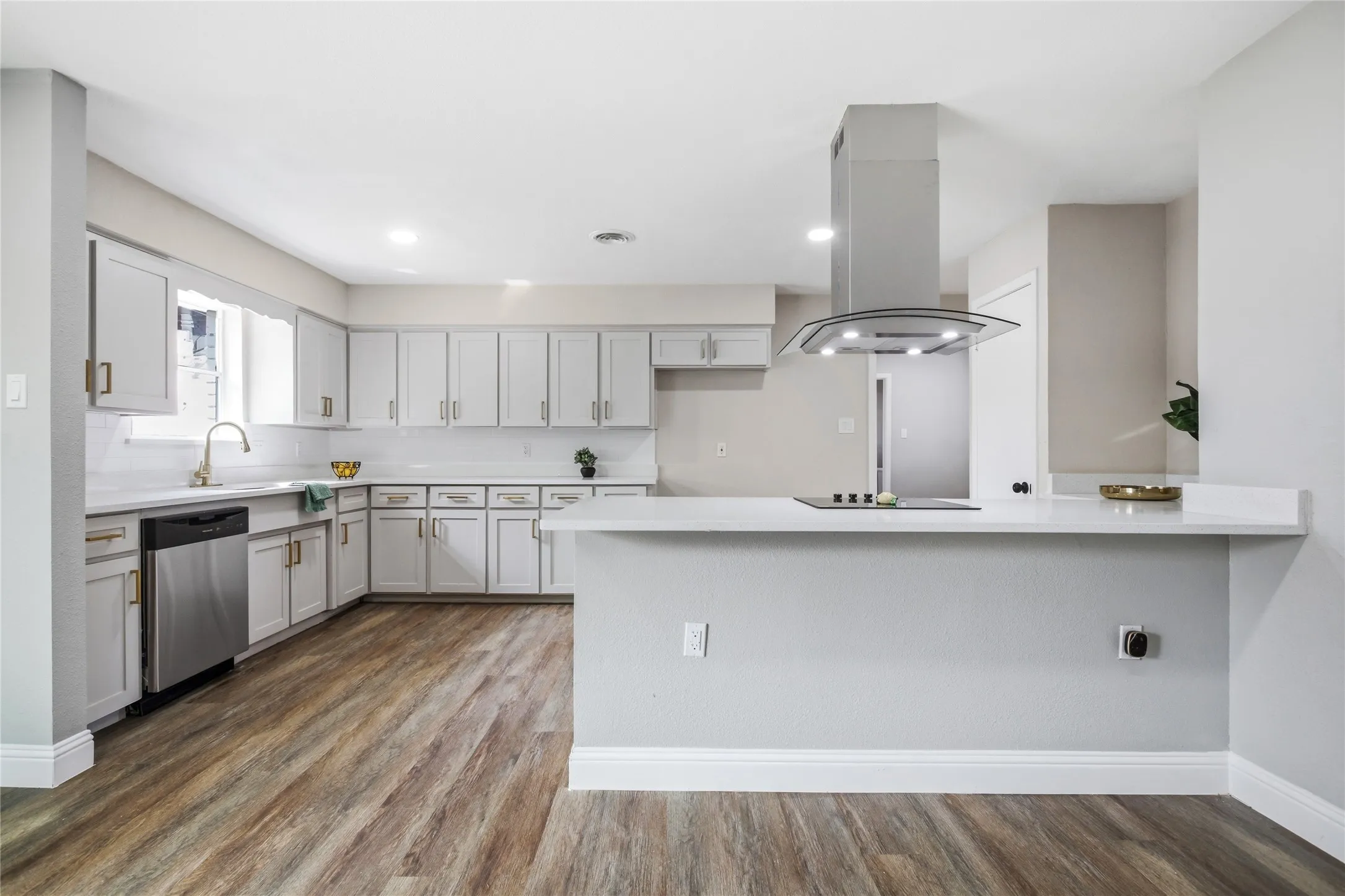 Wood-finish flooring with white baseboards and light gray walls