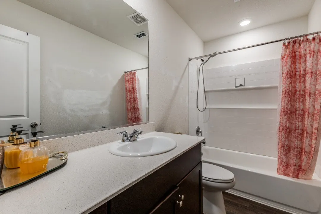 White single-basin vanity with a light-colored countertop and dark wood-finish cabinetry
