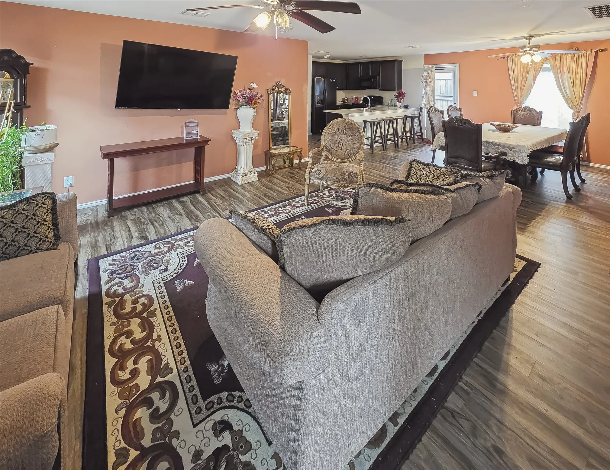 Expansive living area featuring wood-finish flooring, ceiling fans, and an open-concept layout