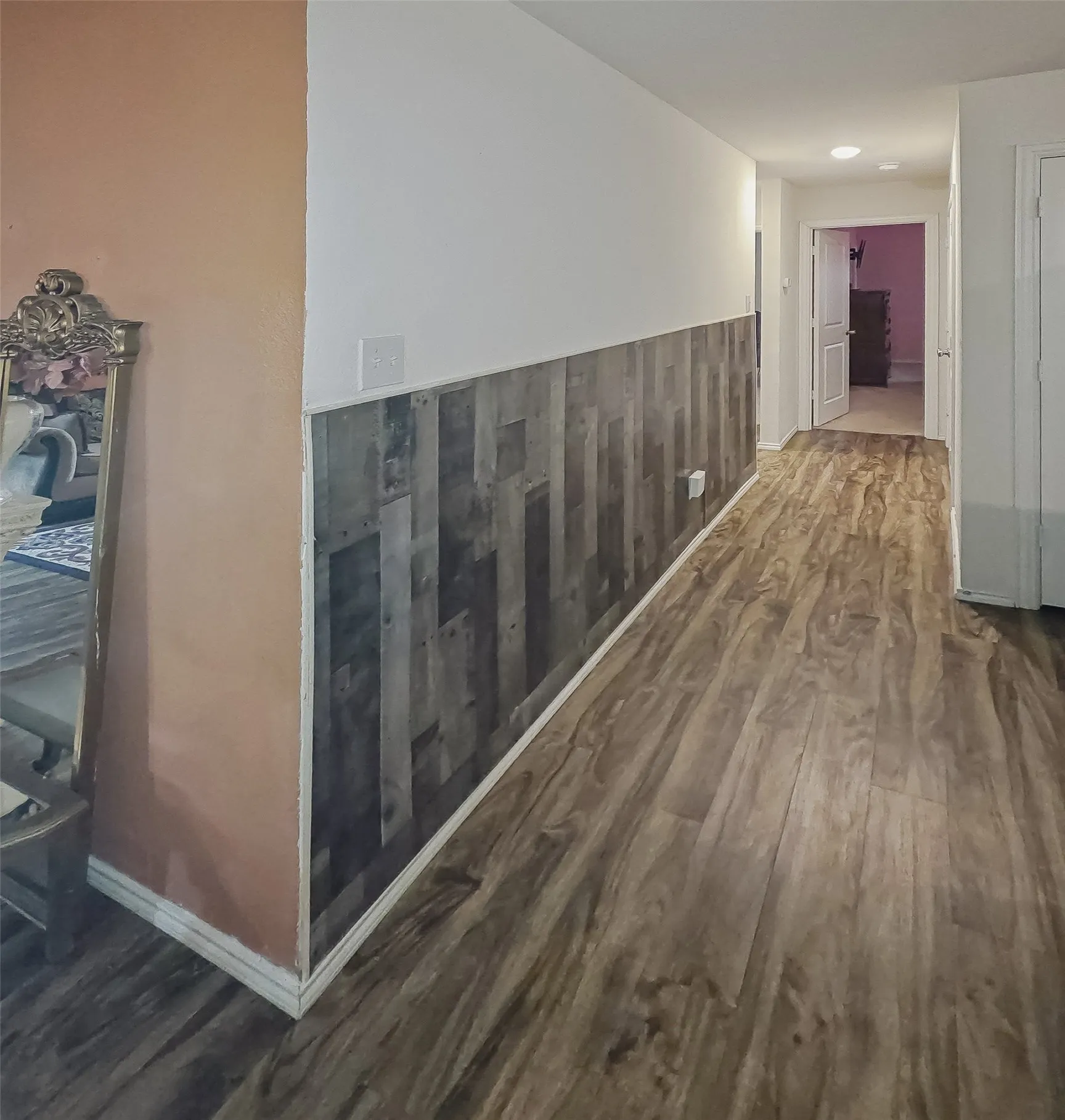 Wood-finish flooring throughout, complemented by a decorative wainscoting paneling