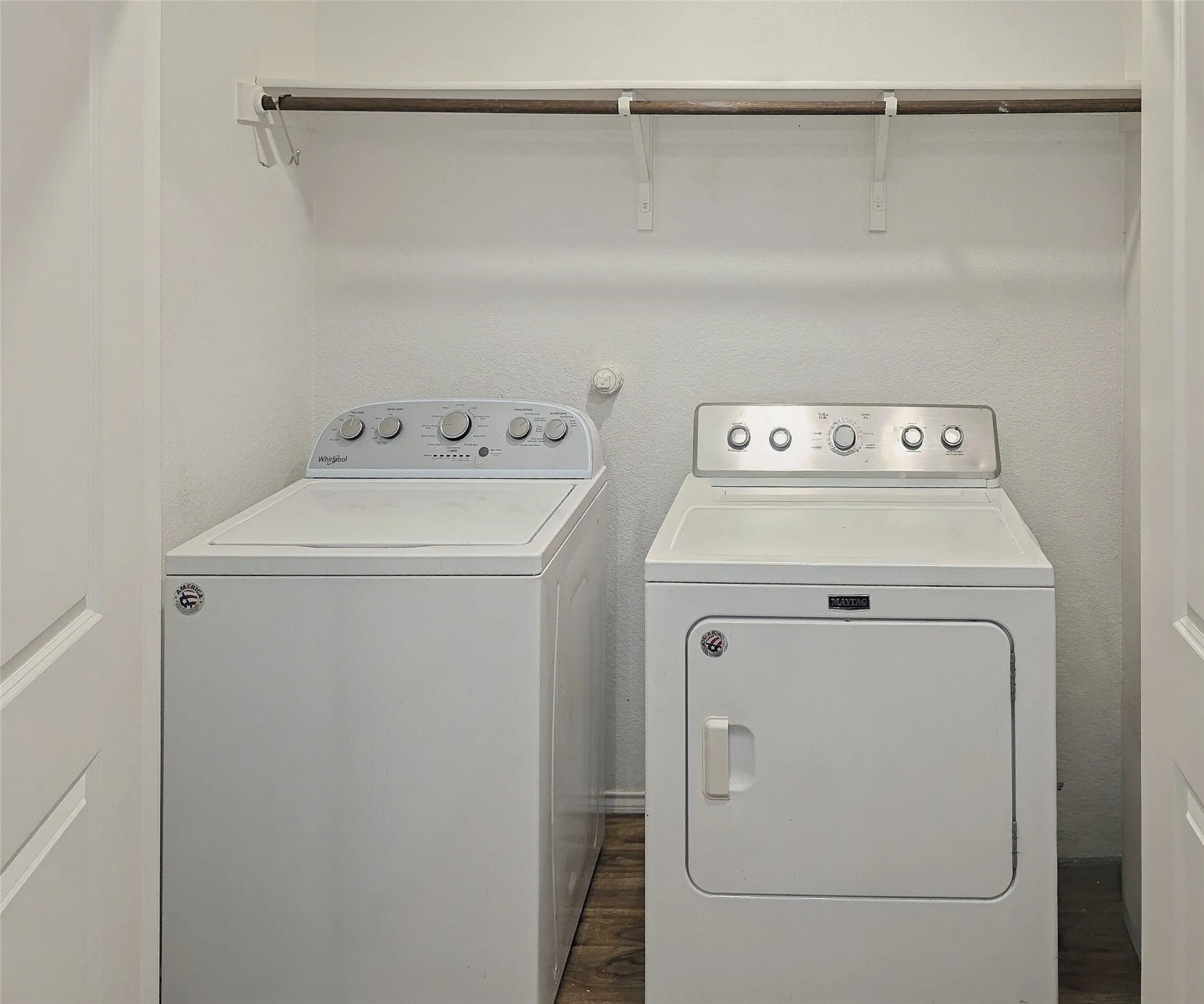 Dedicated laundry space featuring a white top-load washing machine and a white front-load dryer