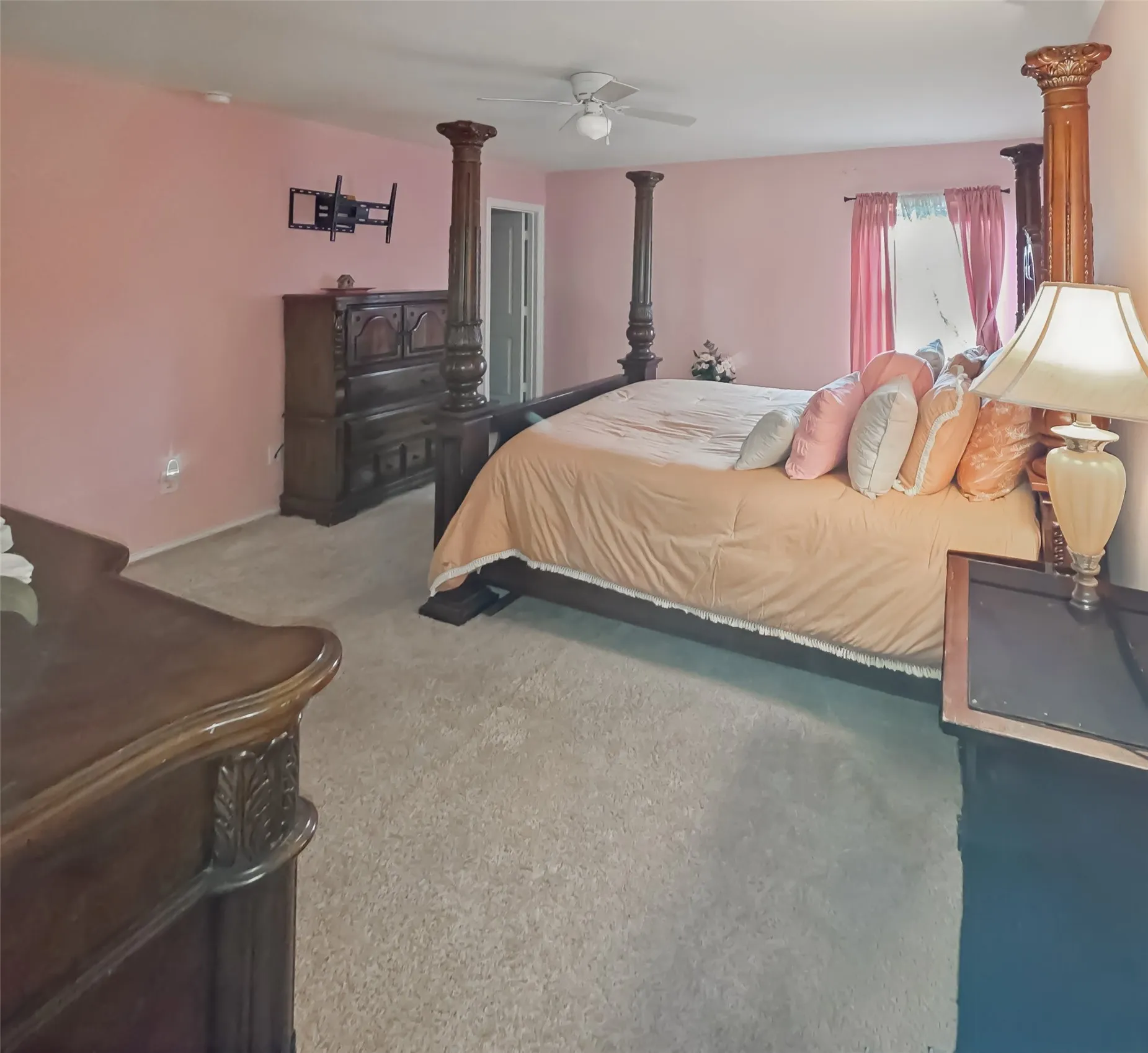 Wall-to-wall carpeting, ceiling fan, window with vertical blinds, and a permanent wall-mounted bracket