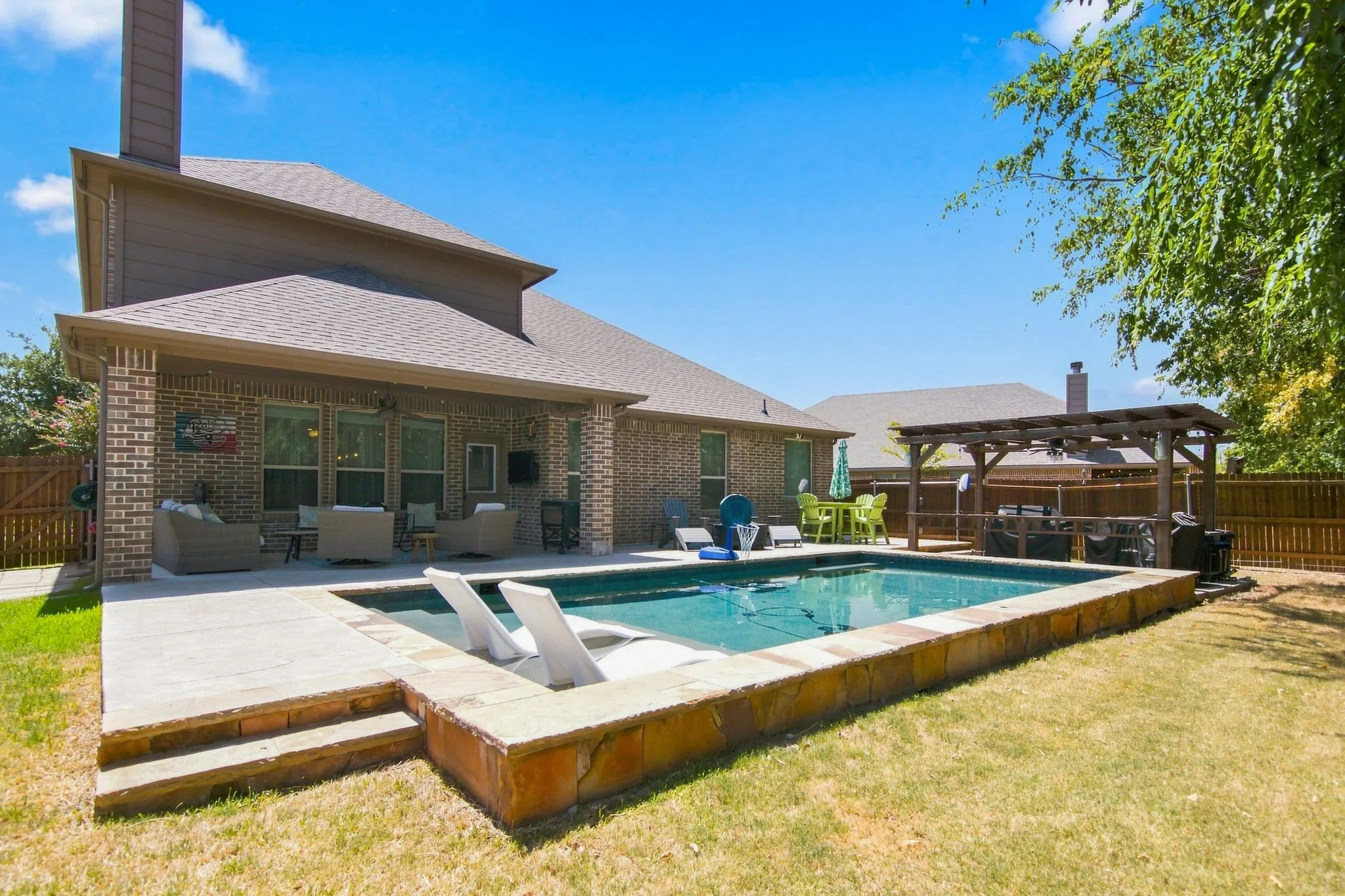 Pool with tanning ledge, covered patio, pergola and extended open patio area for more seating.  Come and enjoy your new home inside and out!