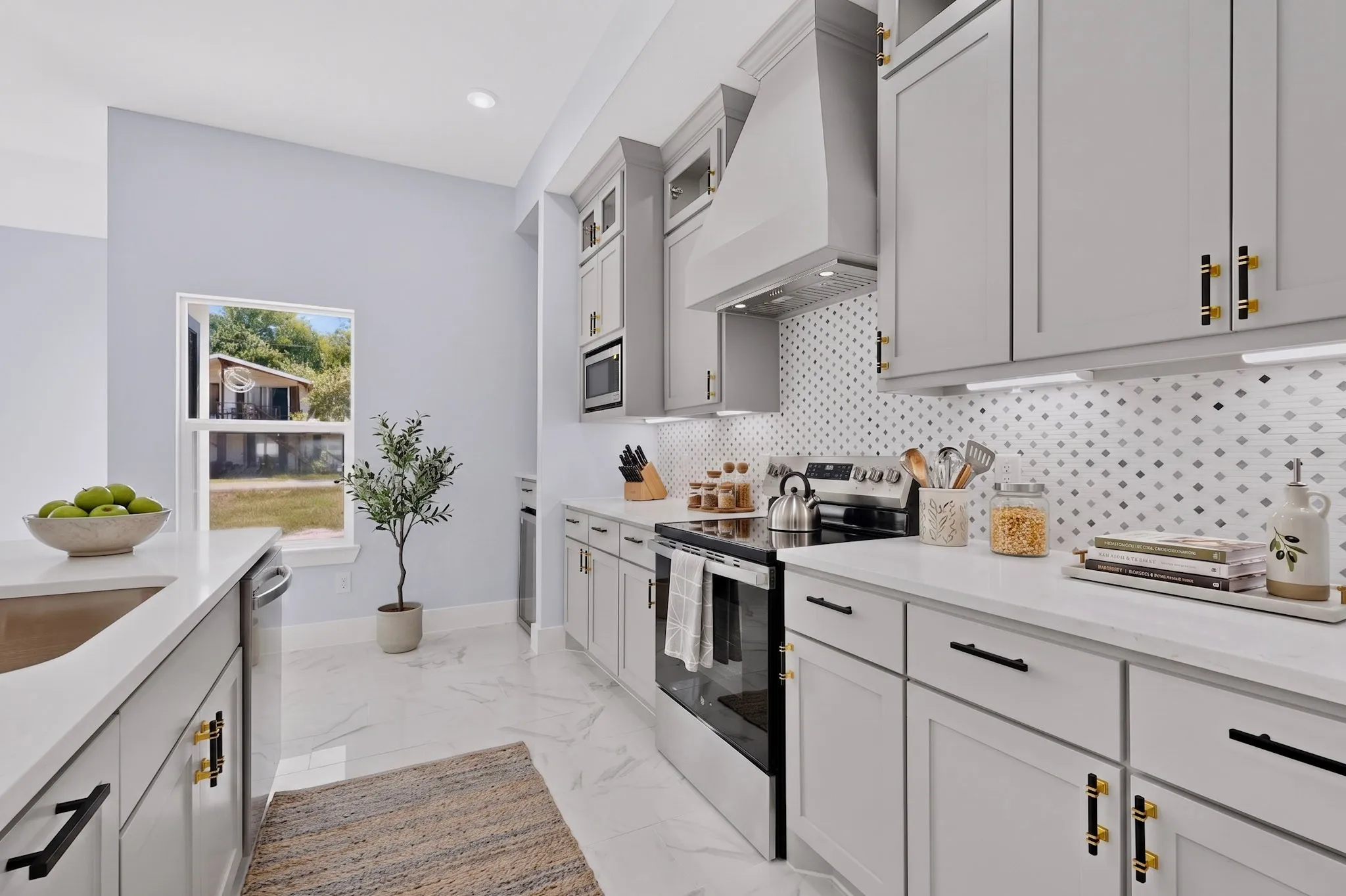 White quartz countertops, light gray cabinetry, stainless steel appliances, patterned tile backsplash, and recessed lighting