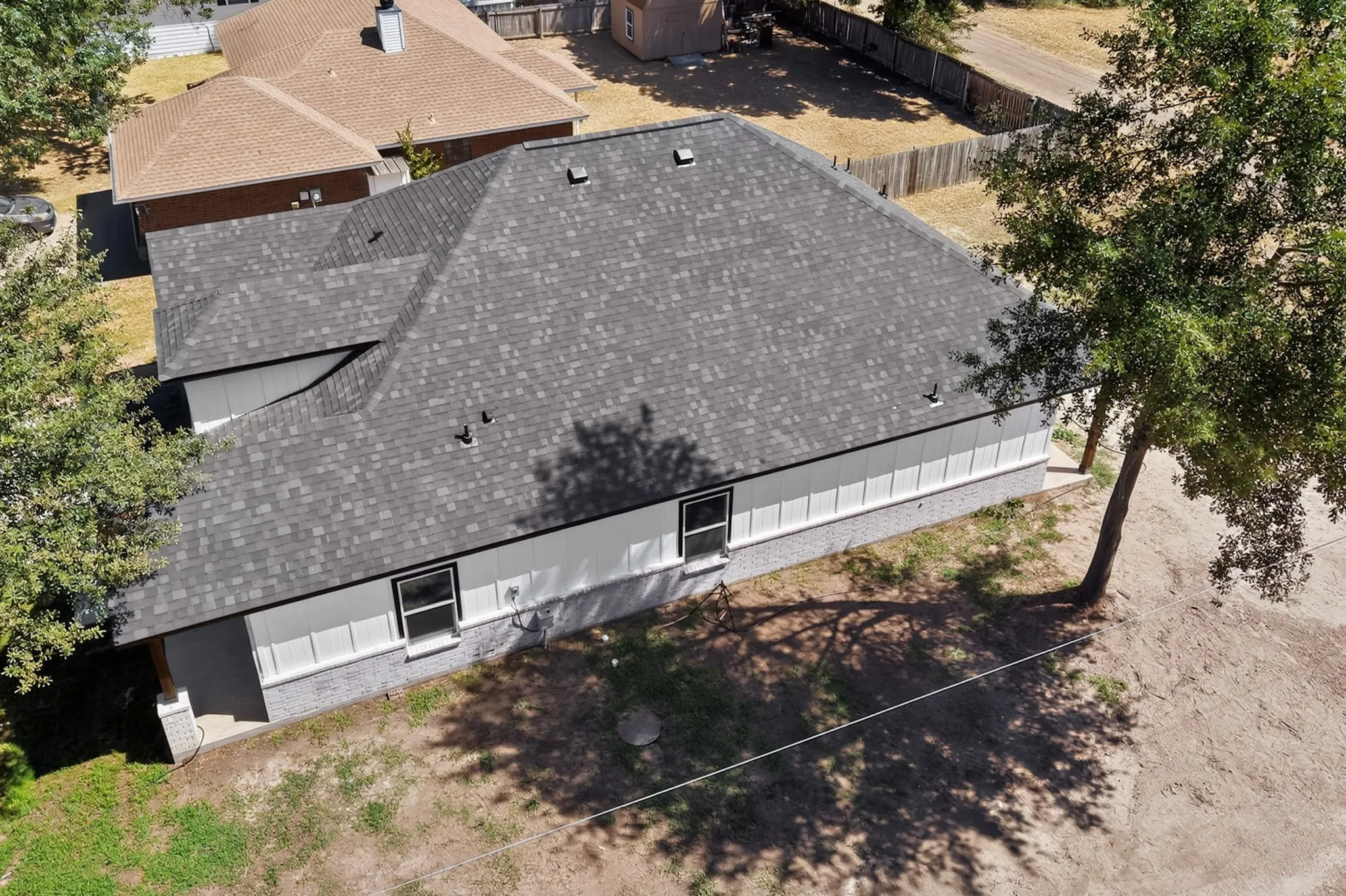 Gray shingle roof, white siding, and gray brick veneer