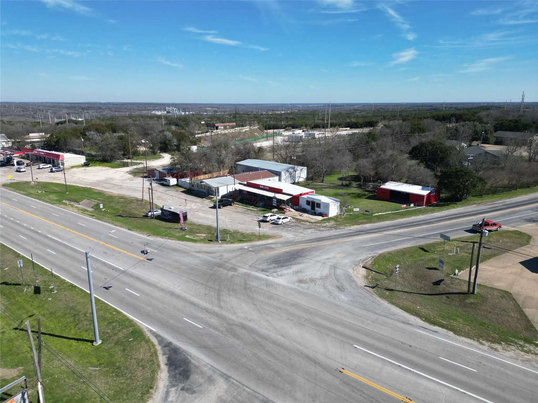 Commercial property with multiple structures, paved road frontage, and ample open space