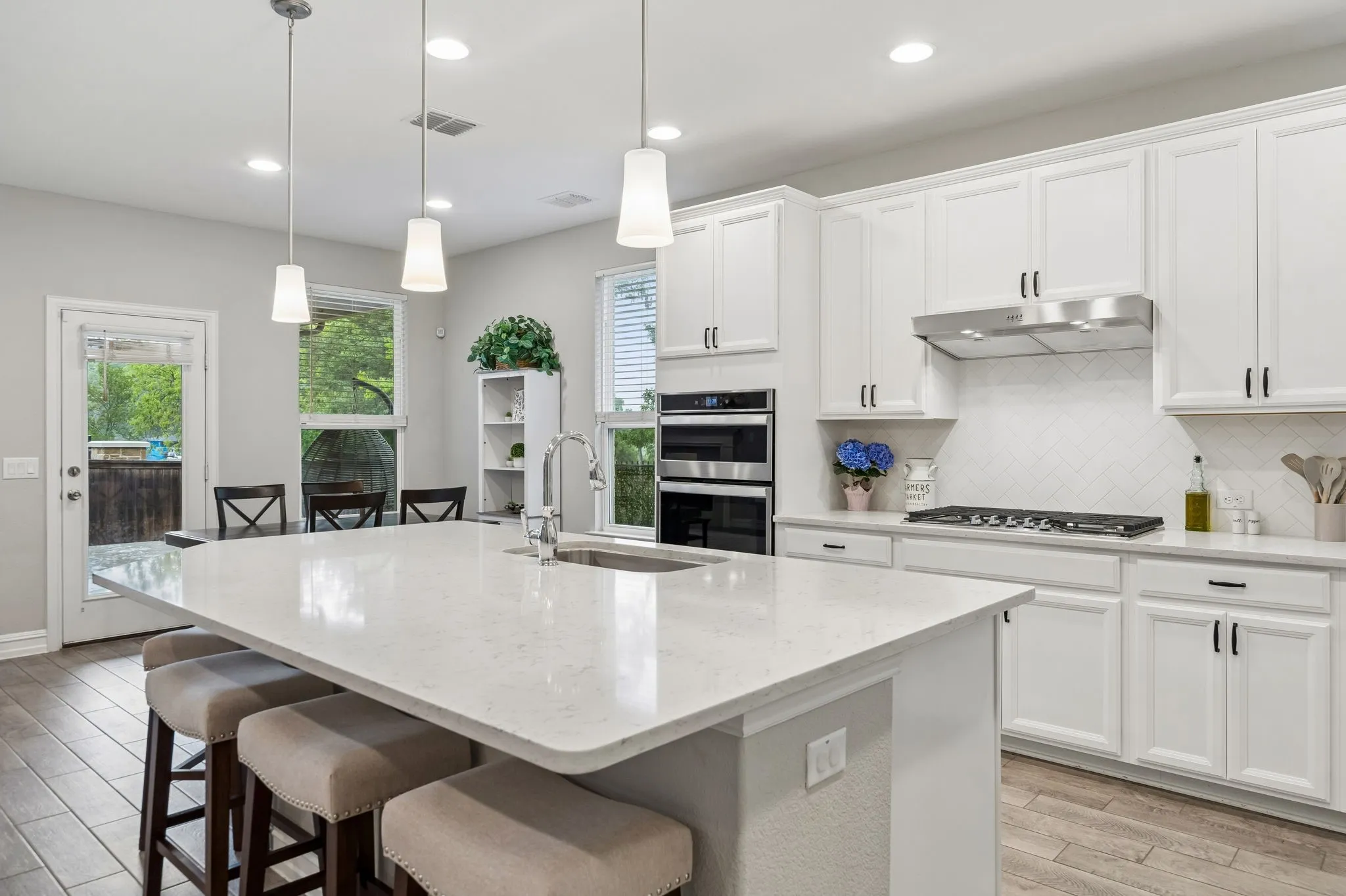 Clean and crisp transitional decor with a huge island for culinary preparation
